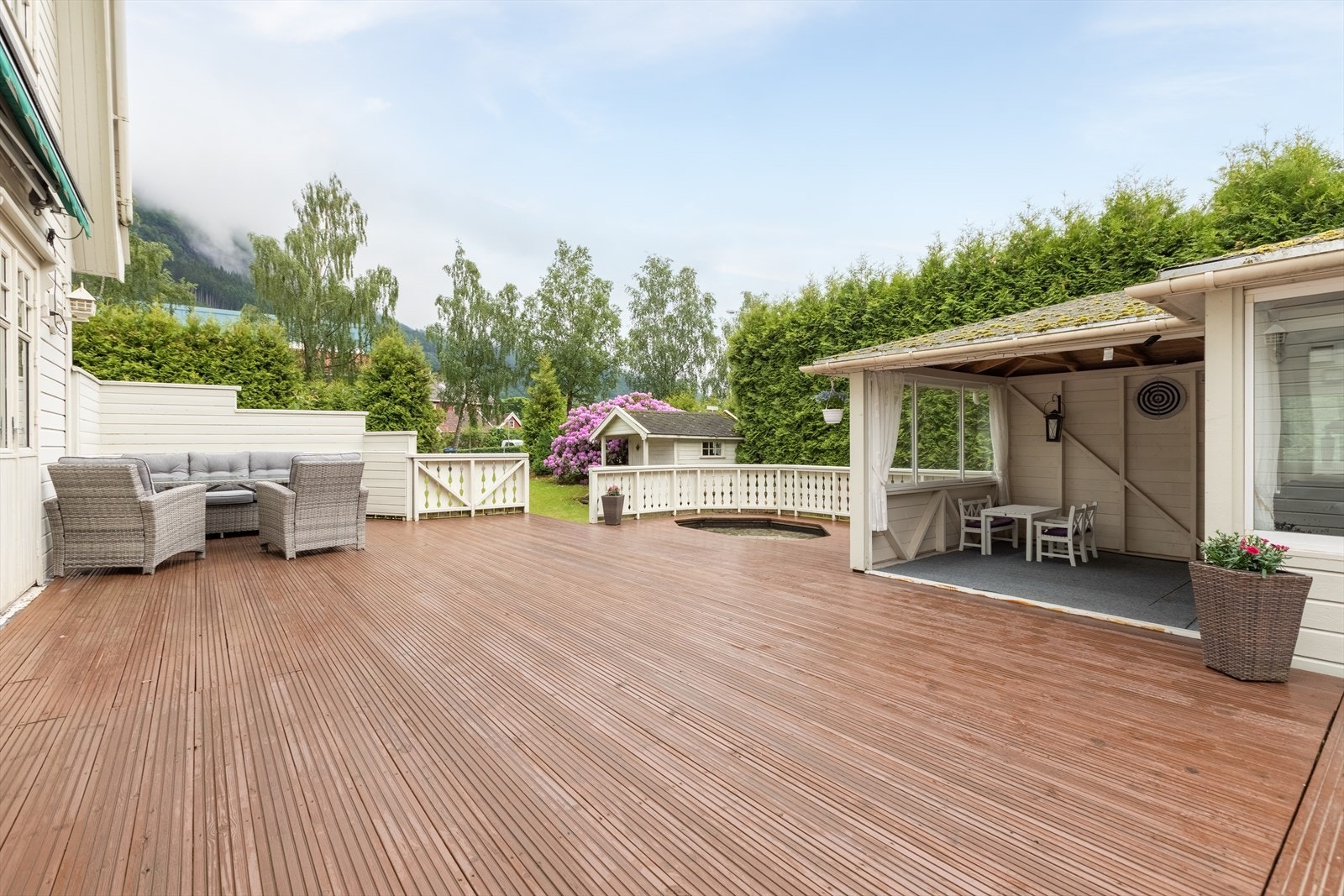 Utvendig er det stor terrasse av tre med utgang frå stove Galleribilde