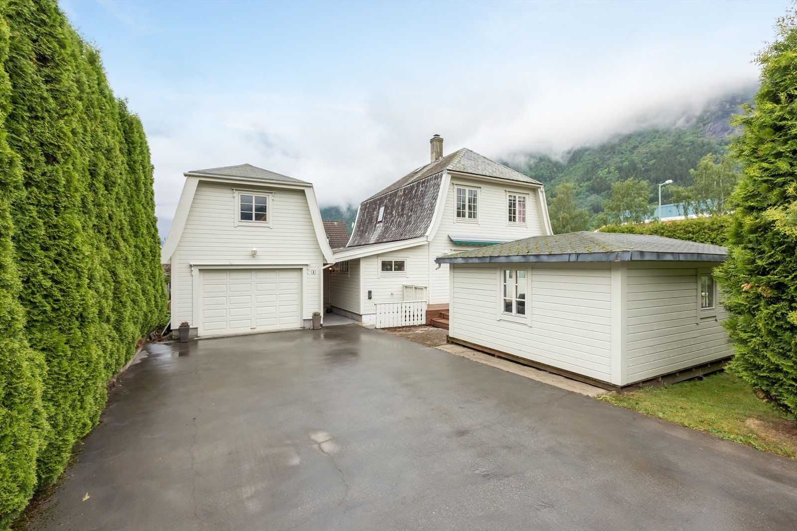 Garasjen har loft til lagring og det er stort lysthus på terrassen i hagen Galleribilde