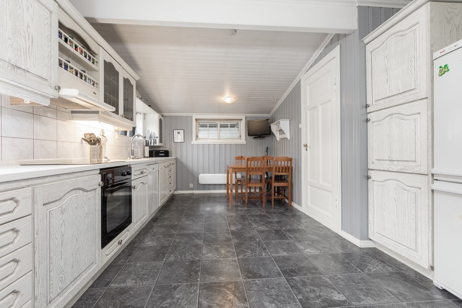 Møbelfrontar er i kvit utførelse, og på vegg mellom benkeflate og overskåp er flis Galleribilde