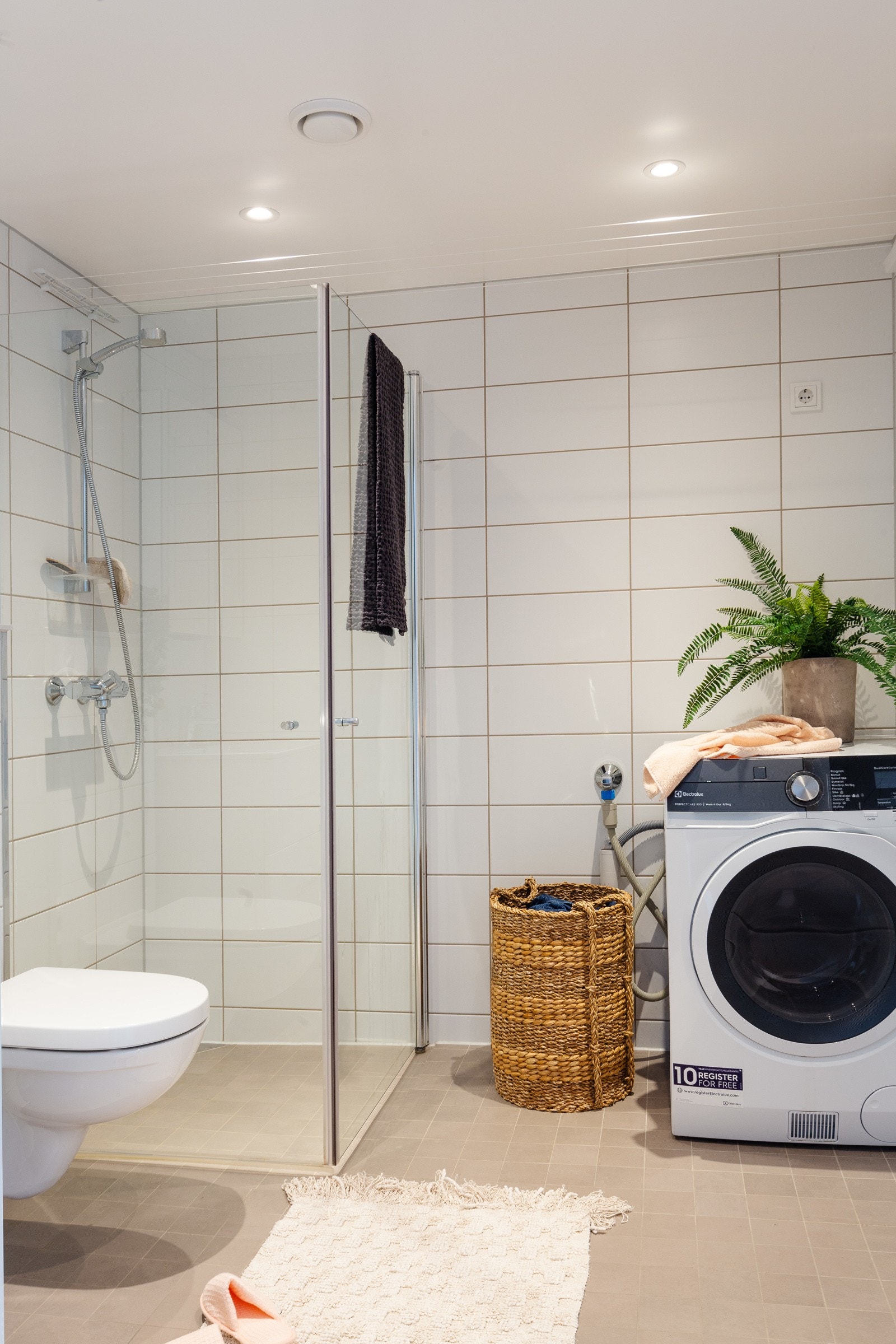 Rommet har lun gulvvarme, flislagte overflater, opplegg for vaskemaskin, dusjhjørne, smarte tørkeløsninger og vegghengt klosett. Galleribilde