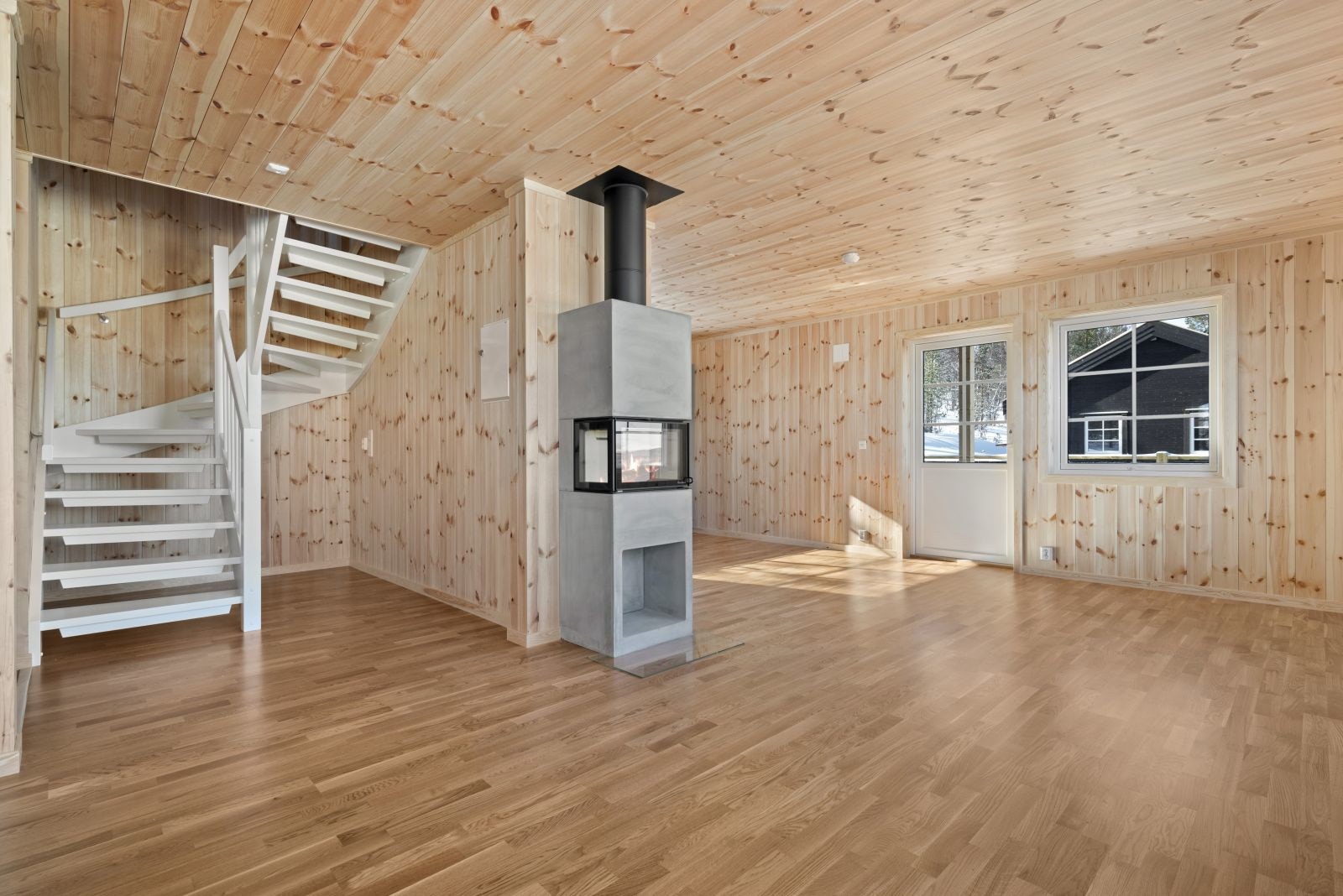 Peisen i stuen er strategisk plassert og har stort glassfelt slik at man kan nyte innsyn til flammene fra hele rommet. Galleribilde