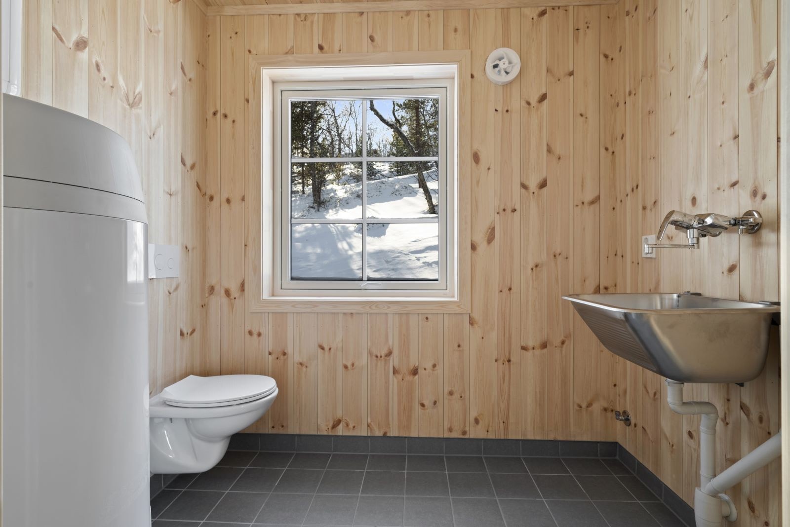 På vaskerommet er det flislagt gulv med gulvvarme, skyllekum, toalett og opplegg for vaskemaskin. Galleribilde