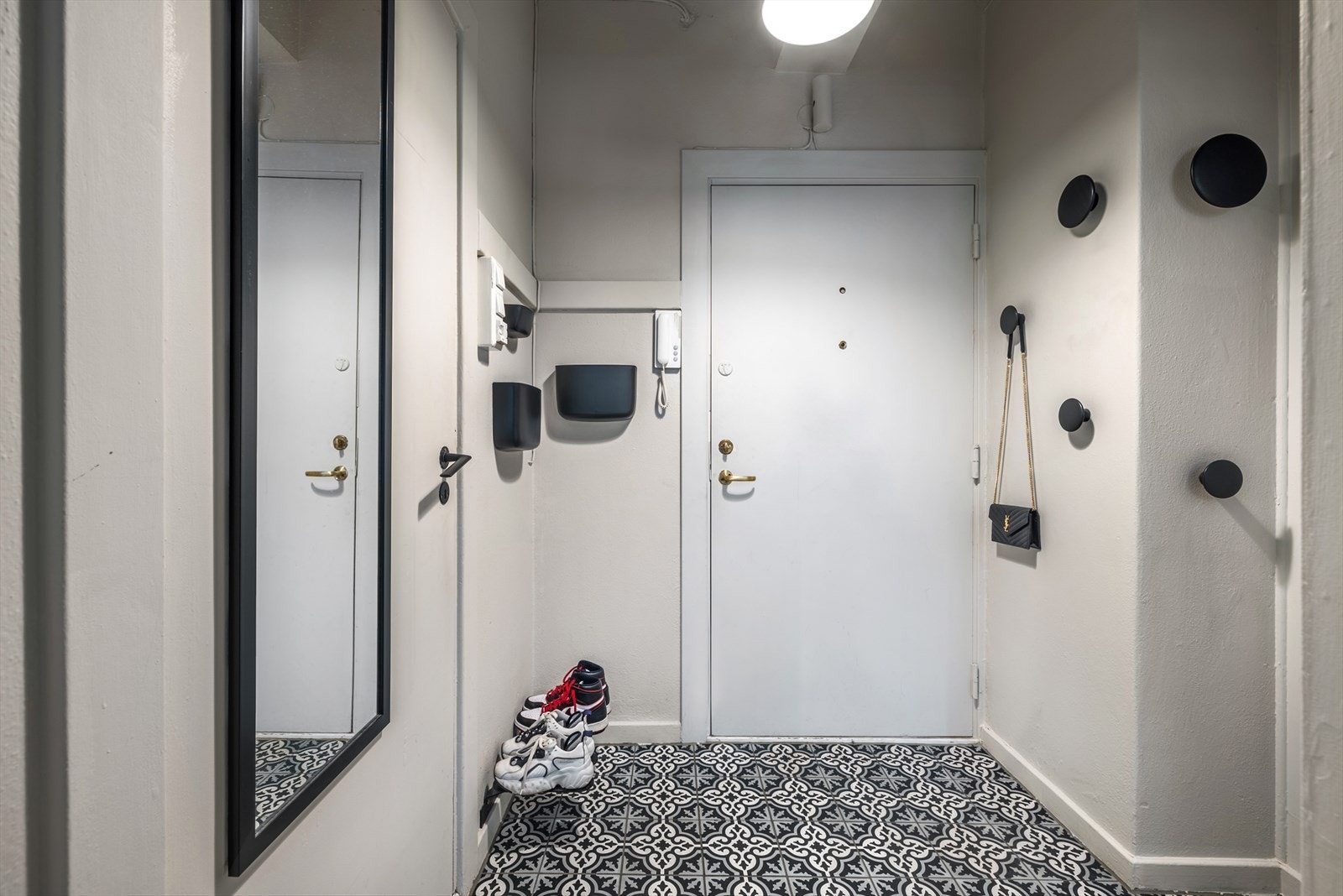 Lys og innbydende entré med plass til å henge fra seg ytterjakke på knaggrekke, samt sette fra seg sko. Galleribilde