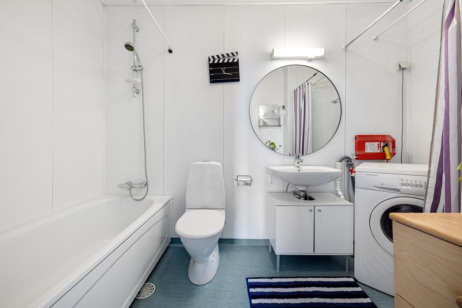 Romslig bad med badekar, toalett, servant med underskap og speil. Galleribilde