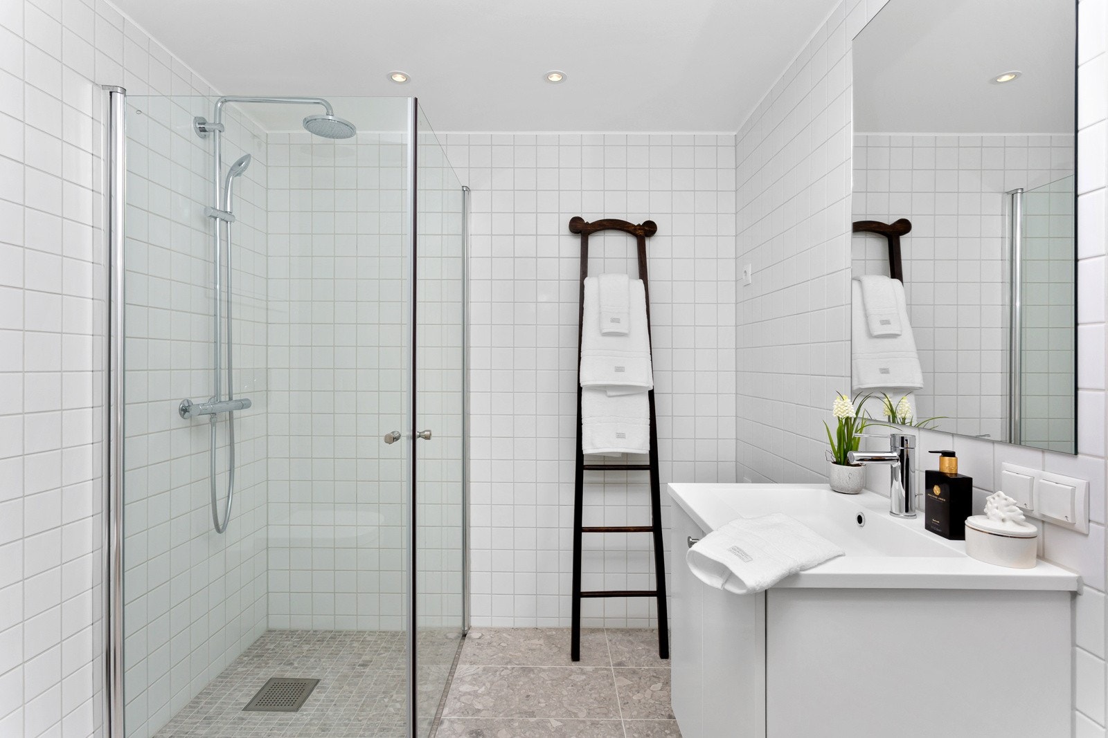 Badet er flislagt med vannbåren gulvvarme, dimbare downlights, dusjhjørne og opplegg for vaskemaskin. Galleribilde