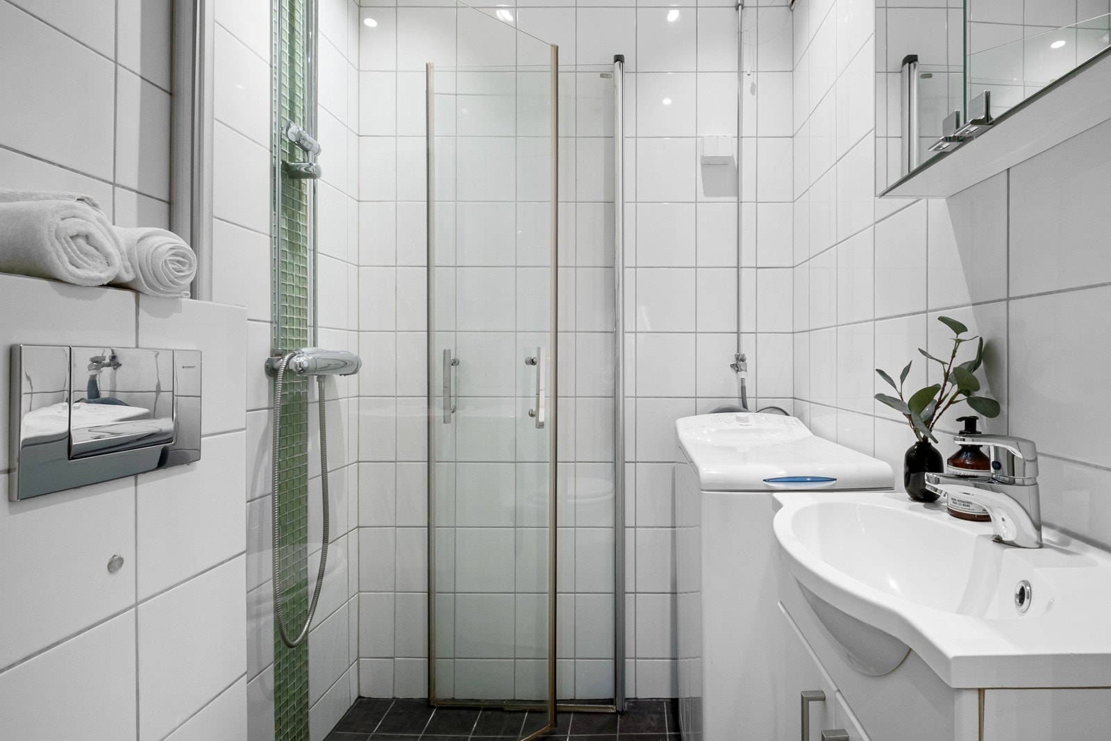 Baderom med grå fliser på gulv og hvite veggfliser. Galleribilde