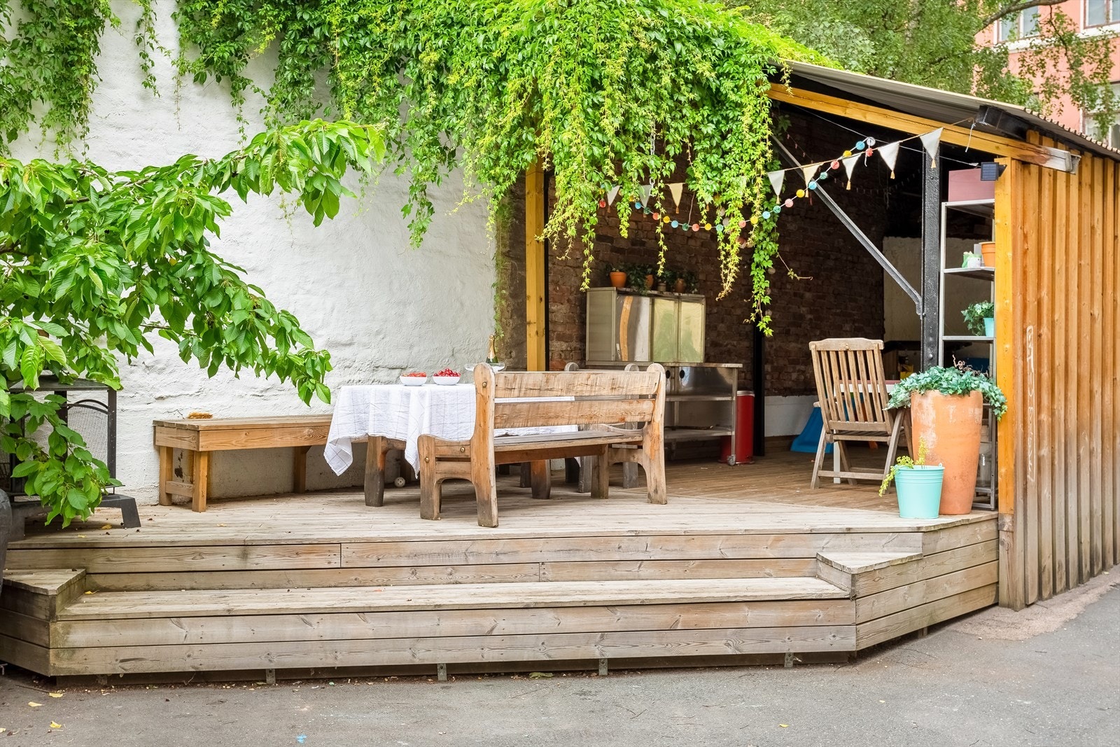Hyggelig bakgård med delvis overbygget terrasse og flere sittegrupper. Galleribilde