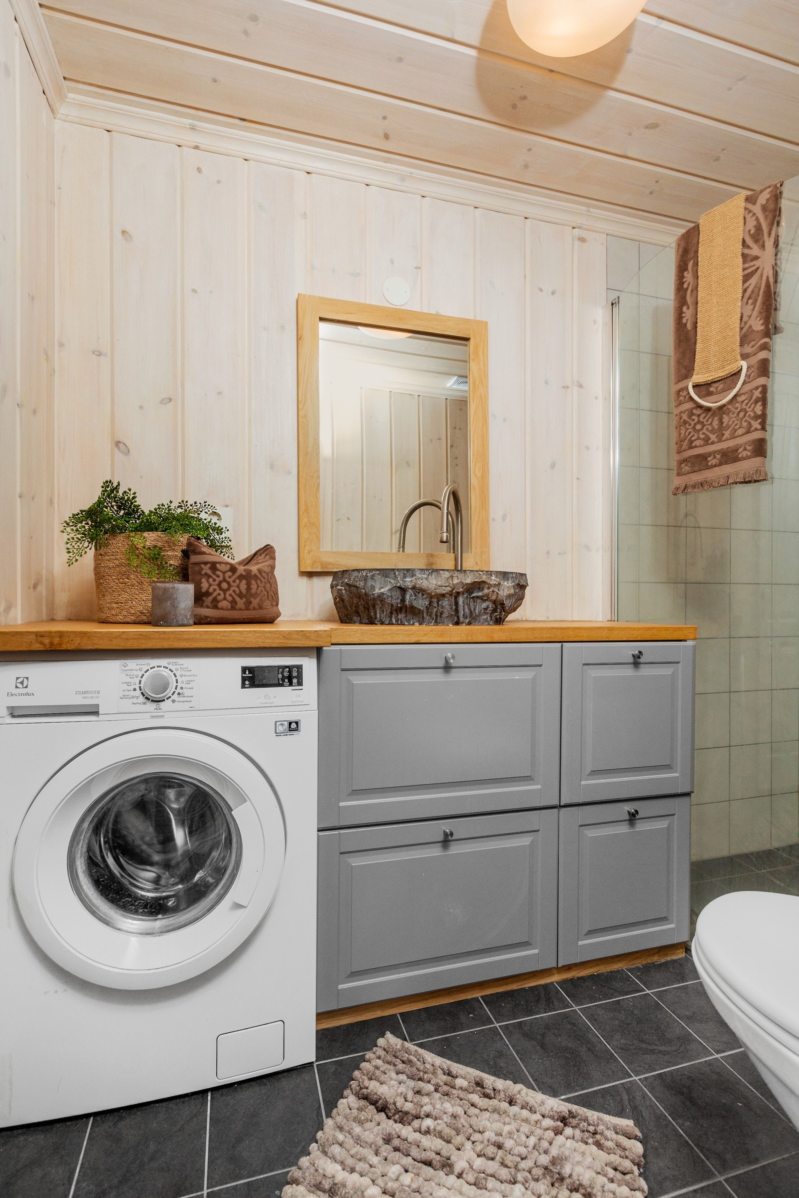 Servant i stein med underskap og oppleg for vaskemaskin. Galleribilde