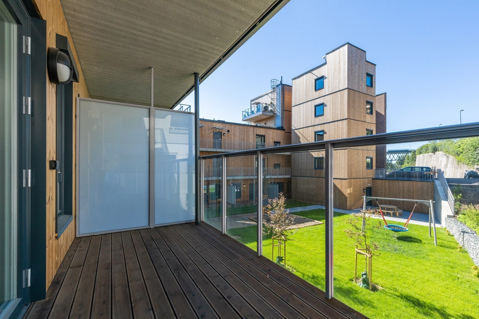 Utgang til overbygget balkong med utsyn over fellesarealene. Galleribilde