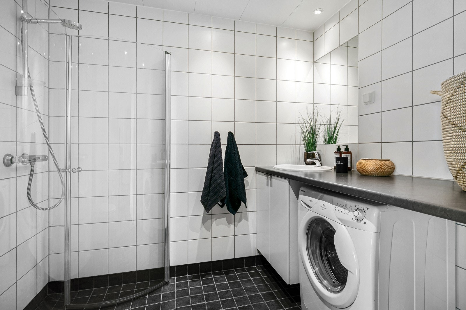 Romslig, flislagt baderom (prefabrikkert baderom) i et tidløst design med flotte gulv- og veggfliser, samt innfelte downlights i himling. Galleribilde