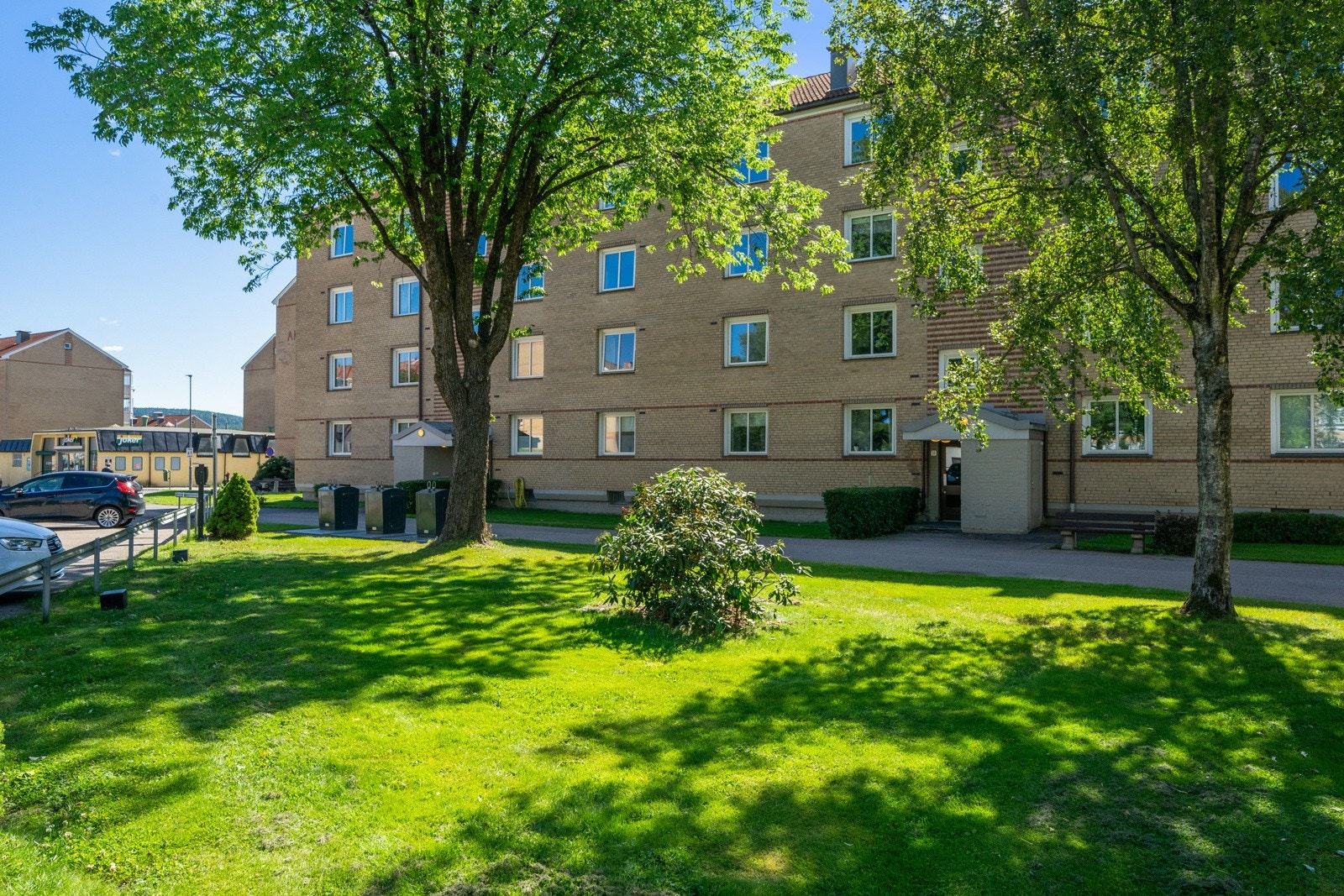Sentralt men allikevel landlig, pent beplantet ved inngangspartiet til blokken. Galleribilde