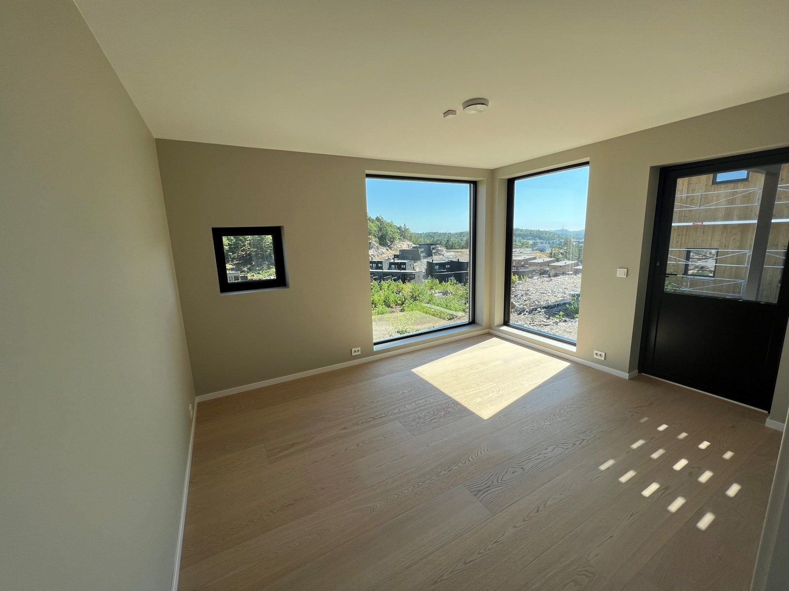 Tv-stue med utsikt og dør ut i hagen Galleribilde