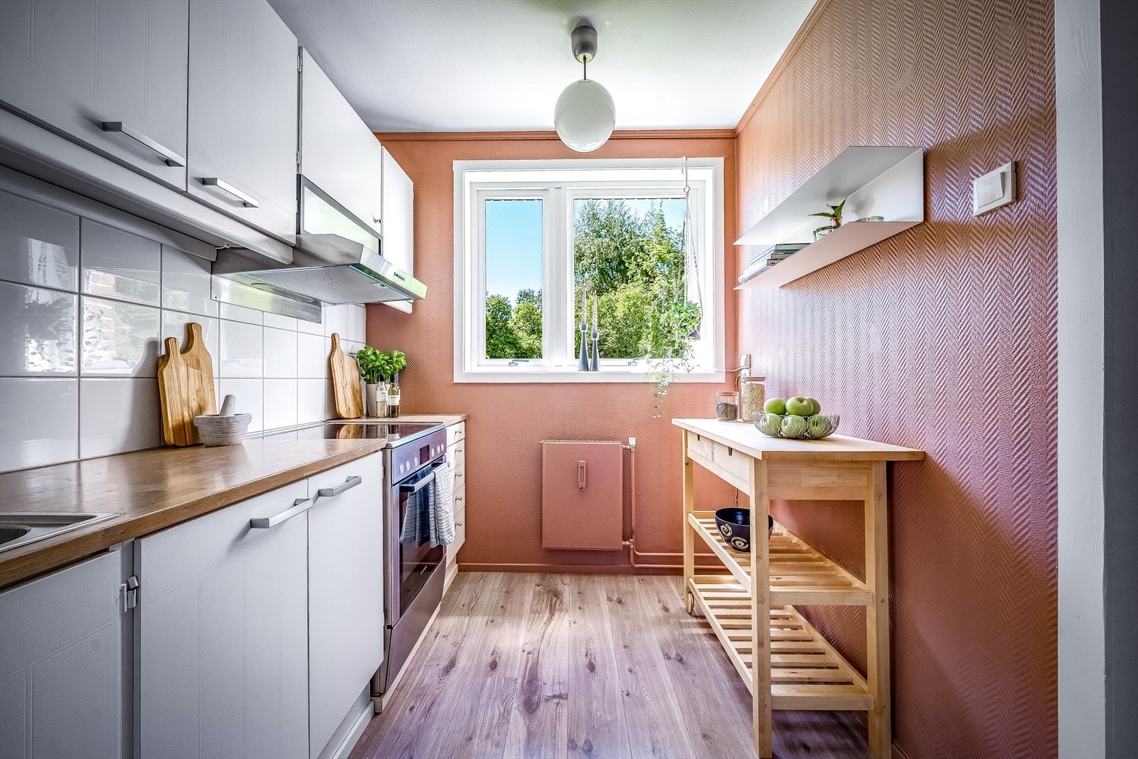 Laminat benkeplate og fliser mellom benk og overskap. Plass til et lite spisebord Galleribilde