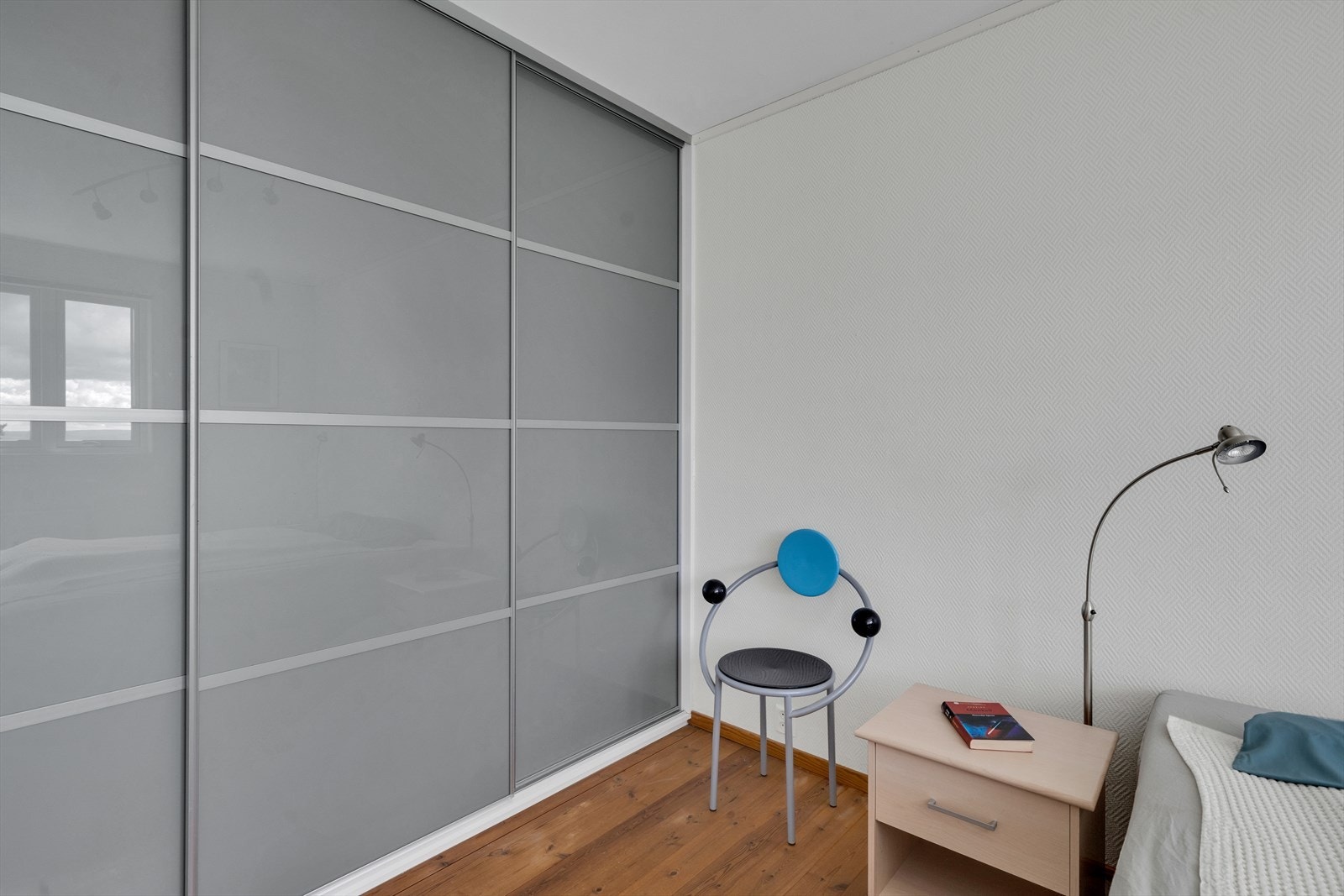 Langs den ene veggen er det montert en stor skyvedørsgarderobe med mye ekstra lagring Galleribilde