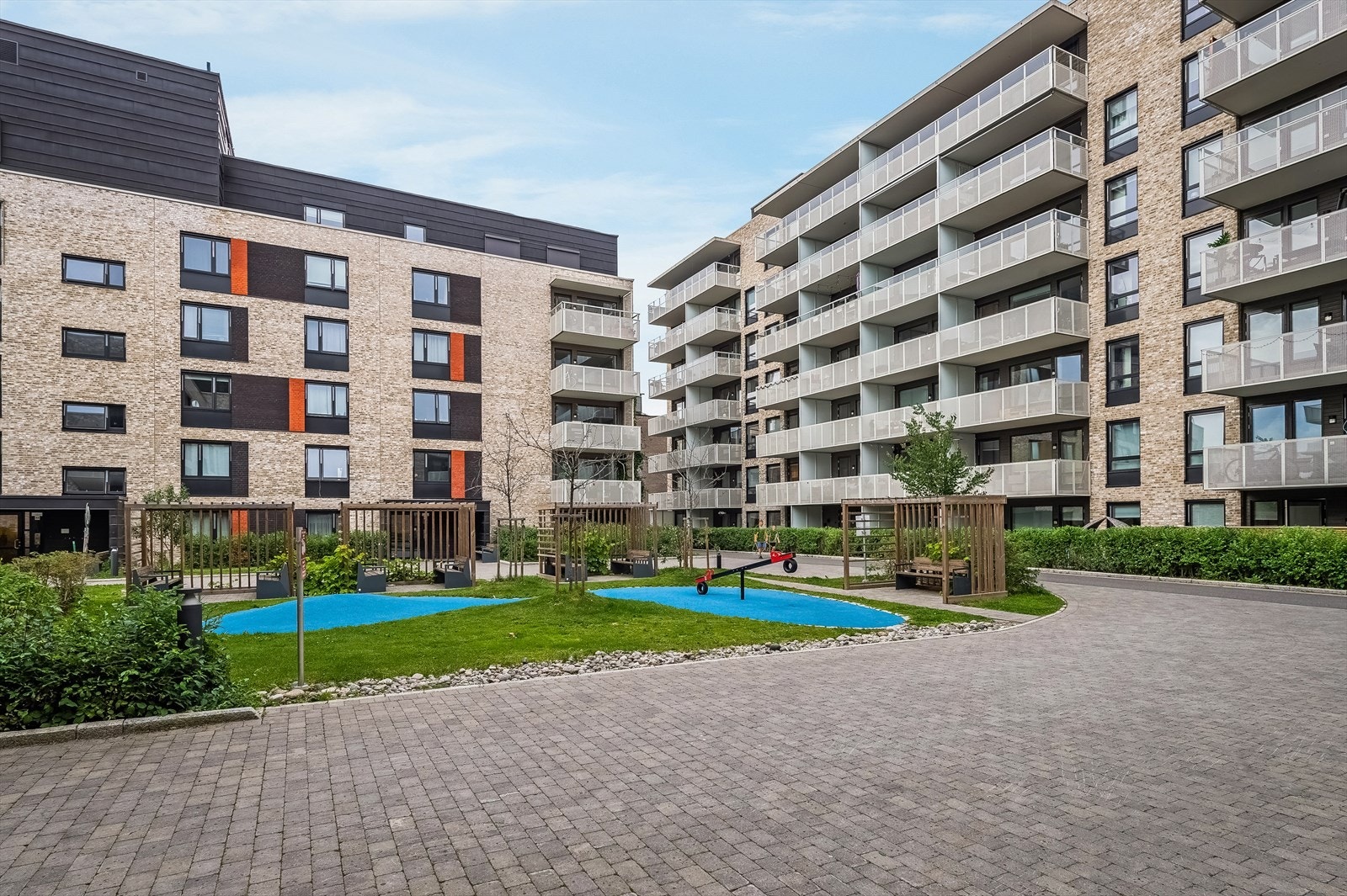 Pent opparbeidet fellesareal med internveier, lekeplass, plen og beplantning. Galleribilde