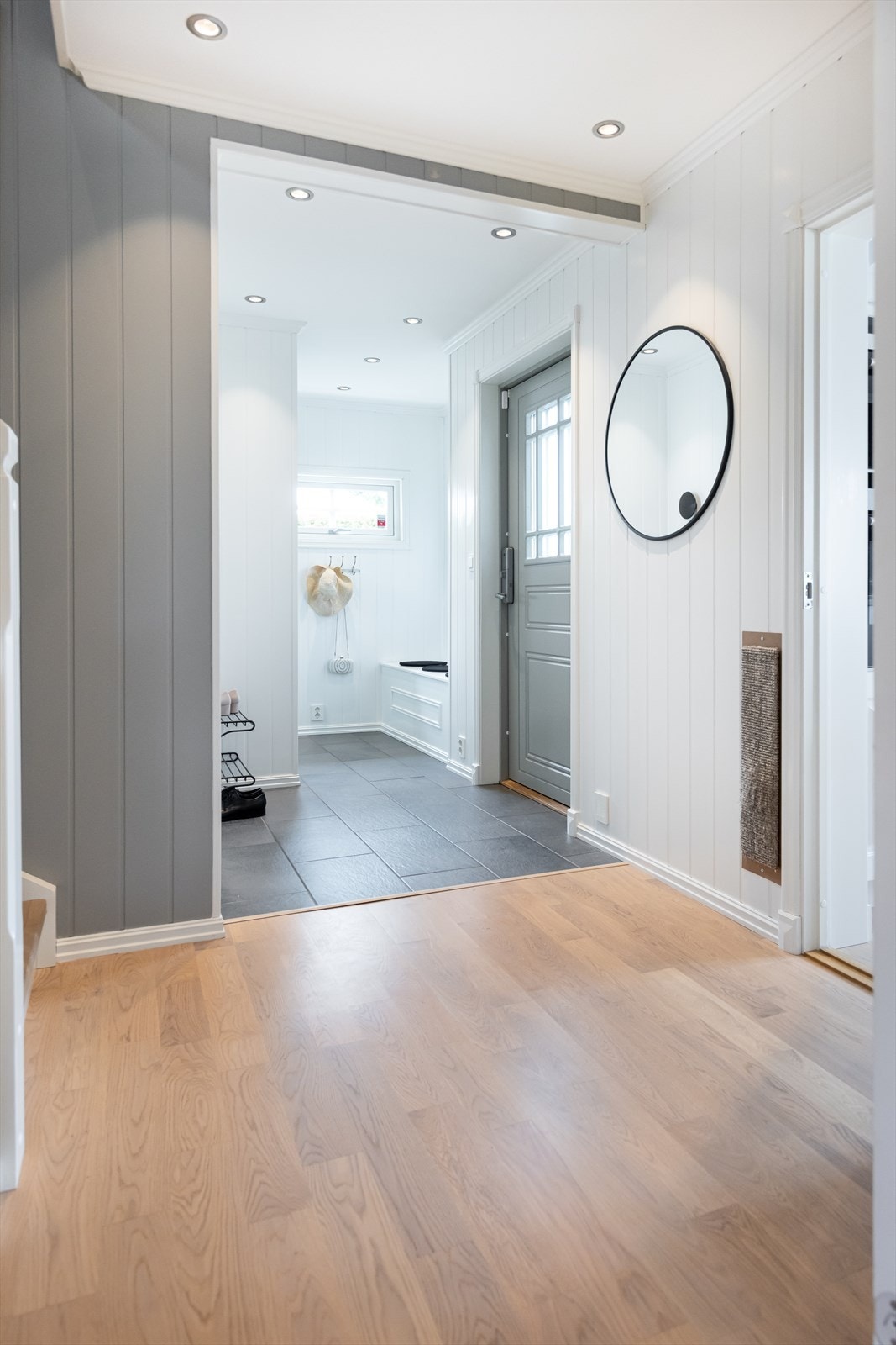Velkommen inn. Innbydende entré med grå gulvfliser, gulvvarme og downlights. Egen knaggrekker og sittebenk. Galleribilde
