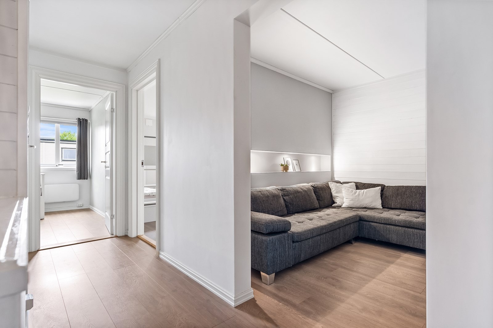 Rommet er innredet med hvite panelvegger, avgrenset til hvitmalte, glatte veggflater, og laminatgulv. Galleribilde