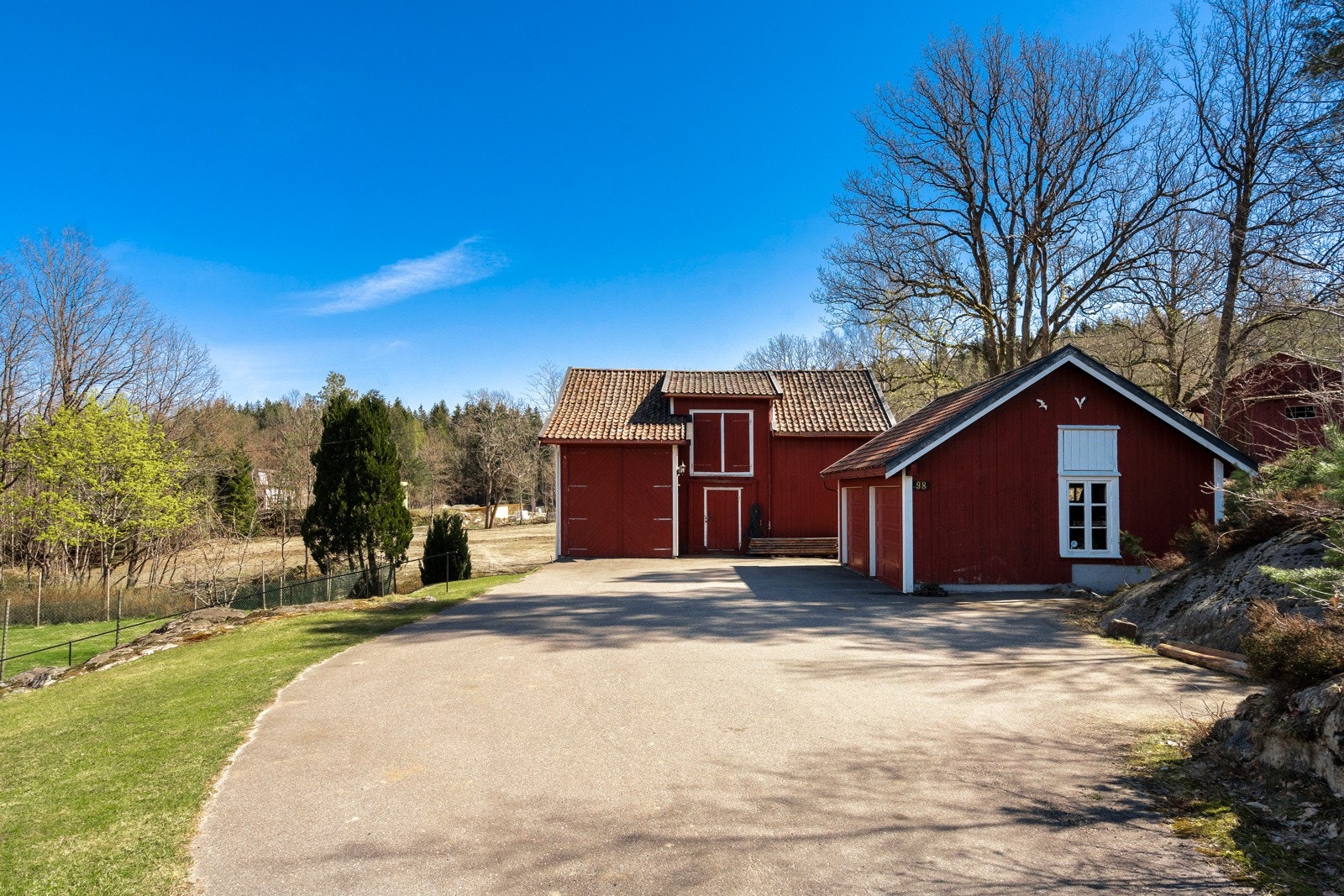 Vei inn til huset med bla. dobbel garasje med automatiske portåpnere. I tillegg låve/uthus med diverse bodrom, samt god plass til lagring på loft. Det er også en høy port for oppbevaring av bobil, båt eller hva en måtte ønske. Galleribilde