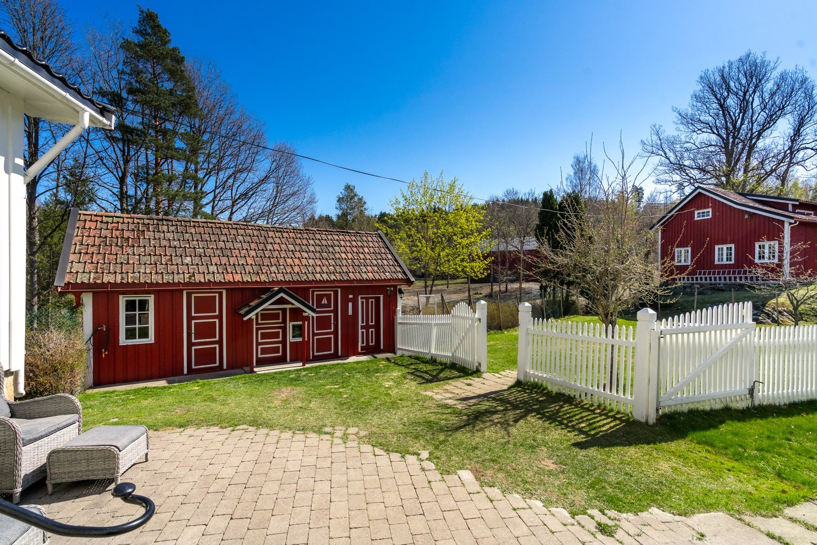 Det er bla. et anneks på eiendommen med diverse boder og med badstue., Meget pent opparbeidet med hvitt stakettgjerde rundt deler av tomten. Galleribilde