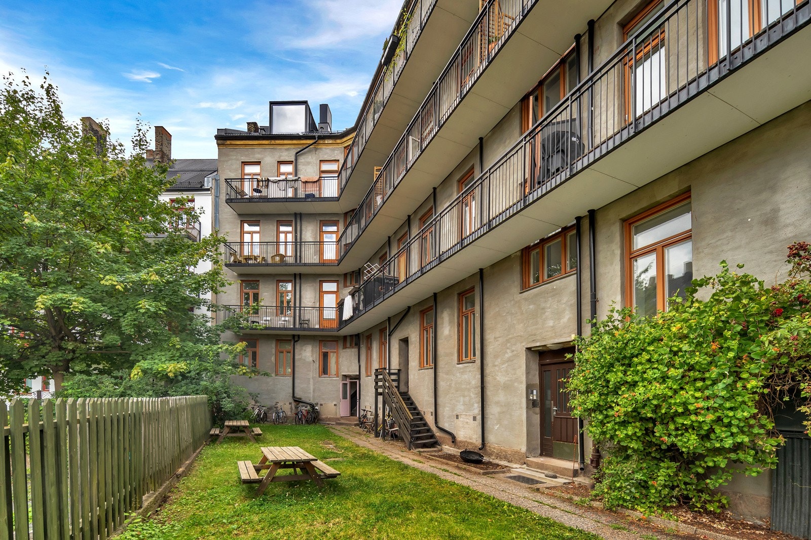 Pent opparbeidet gårdsrom med plen, prydbusker, internveier og sittegrupper. Galleribilde