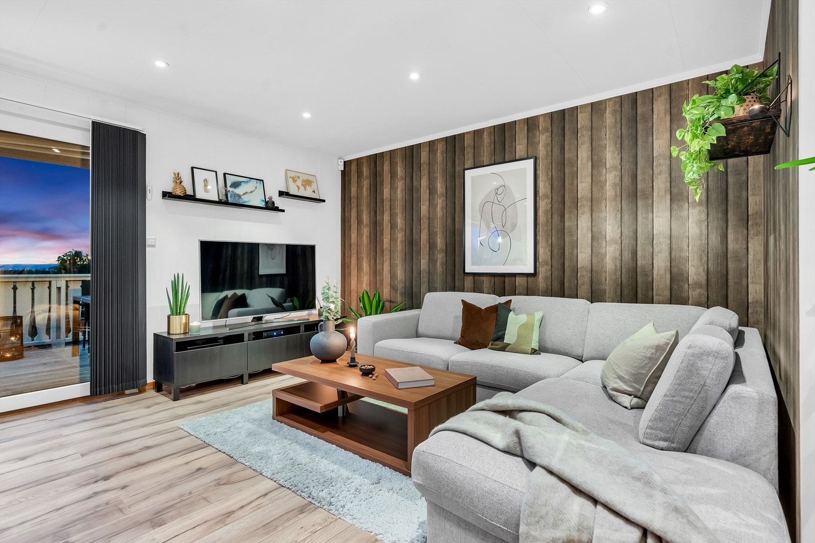 Stuen har downlights i himling, hvitmalt veggpanel og to flotte fondvegger i tv-kroken Galleribilde