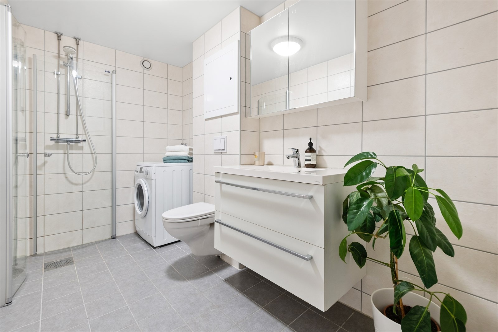 Flislagt baderom med varmekabler i gulvet, pusset opp i regi av sameiet i 2018 Galleribilde