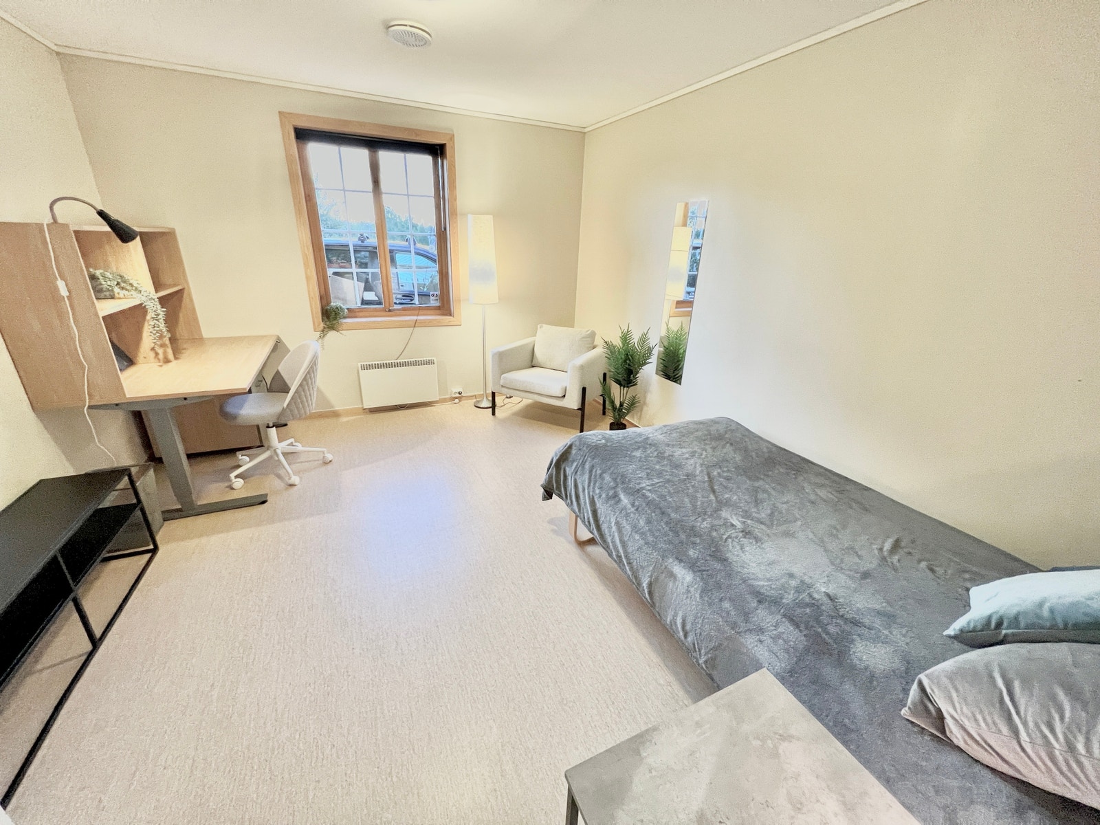 Romslig rom med seng, skap, stol og skrivebord Galleribilde