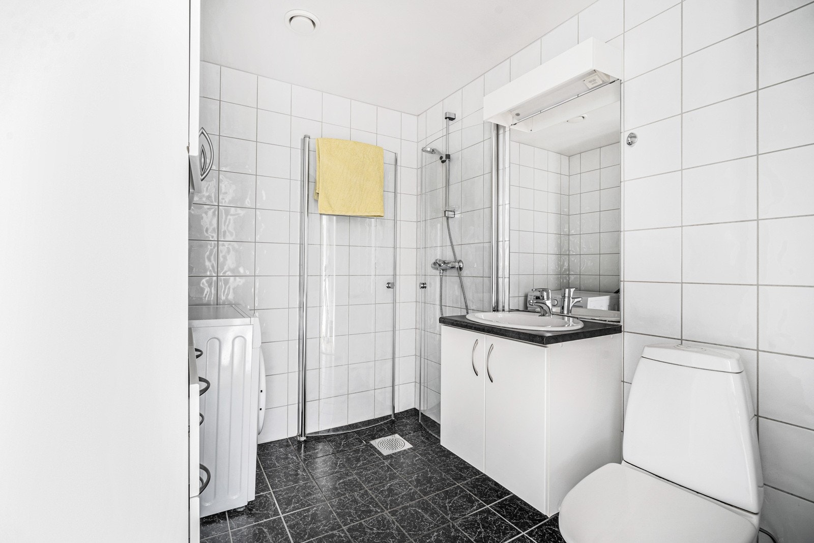 Helfliset bad med god plass til oppbevaring. Opplegg for vaskemaskin og varmekabler i gulv. Galleribilde