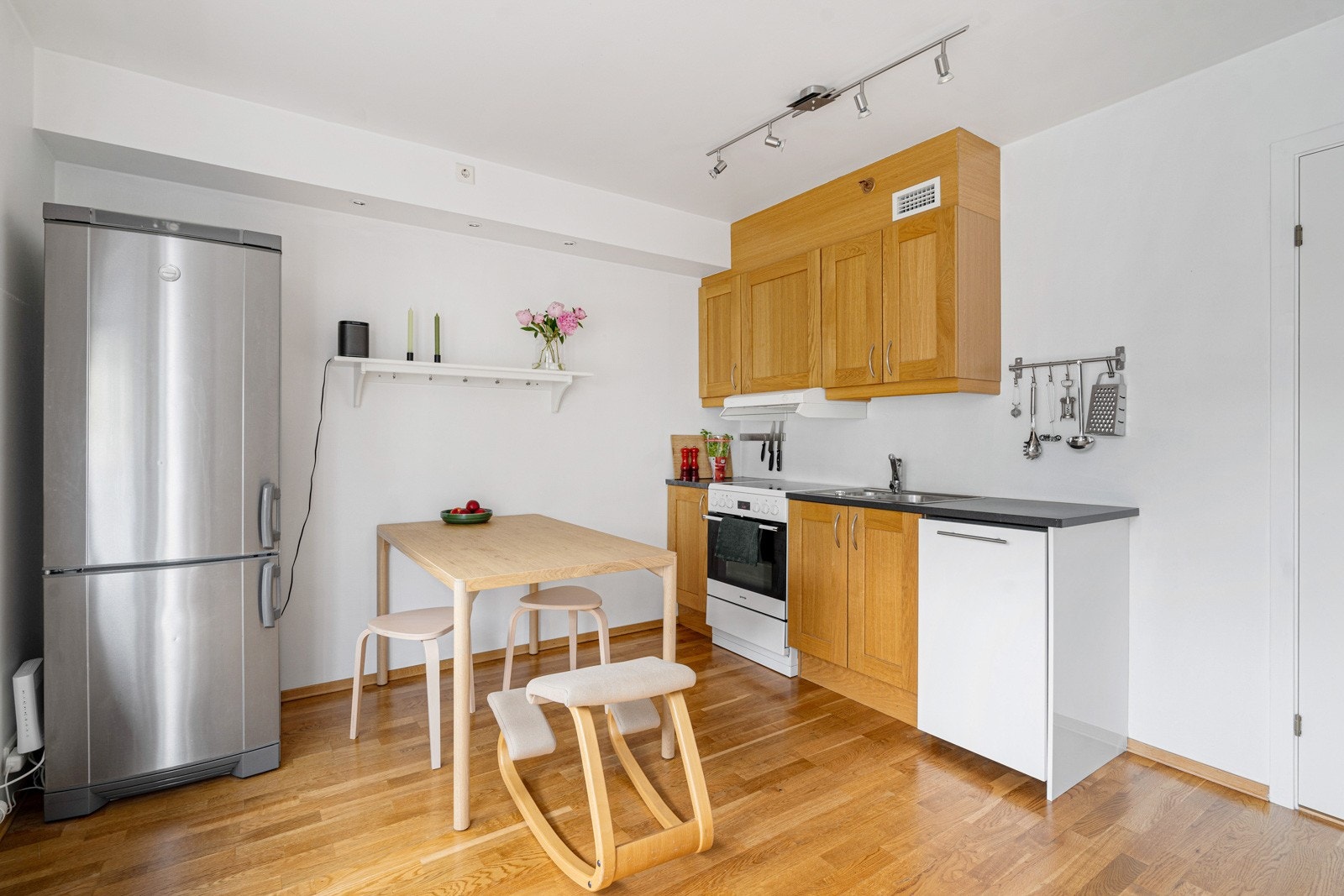 Kjøkkeninnredning med profilerte fronter. Oppvaskmaskin i innredning, komfyr i hvit utførelse og kjøleskap i rustfri utførelse medfølger i handelen. Galleribilde