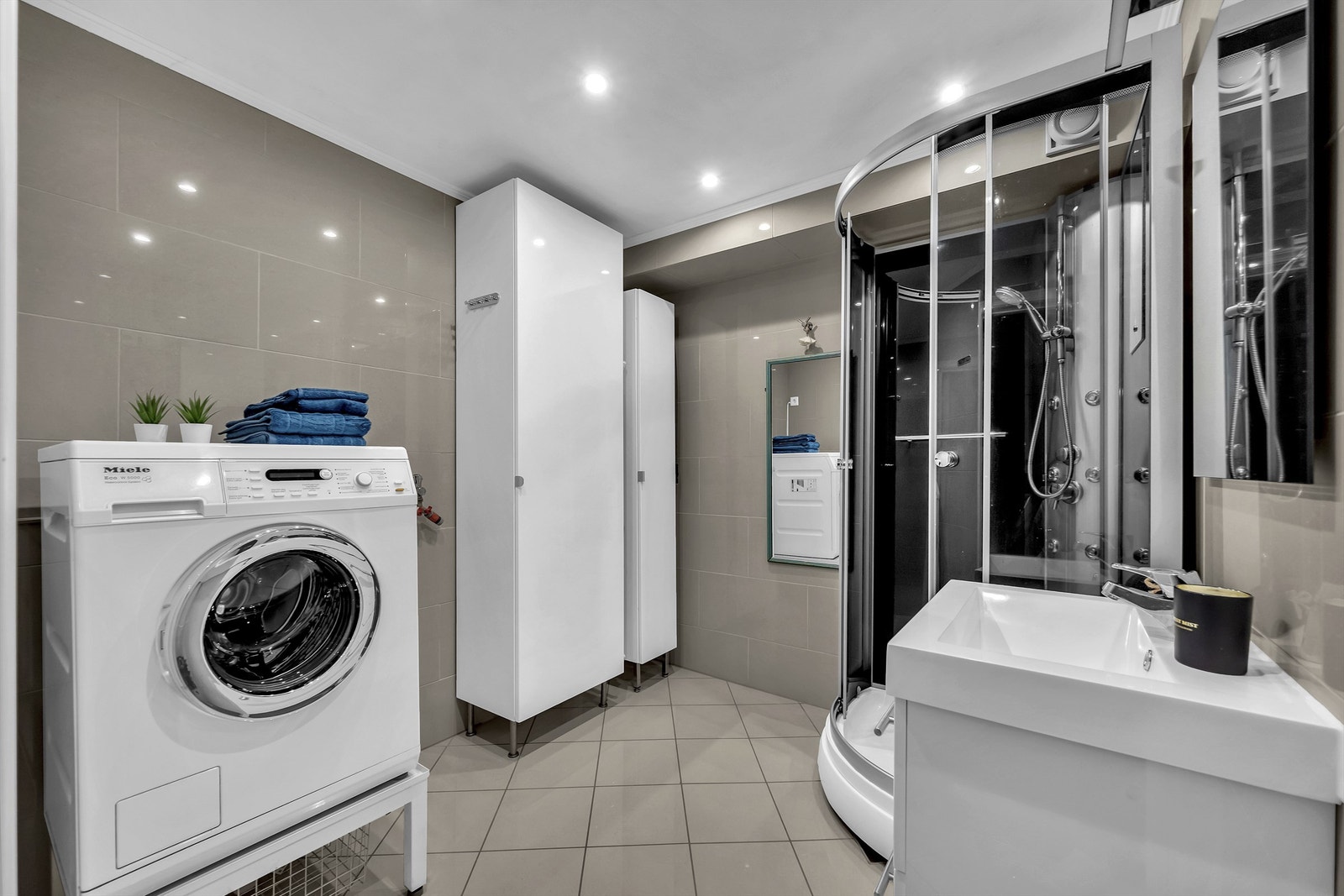 Flislagt bad med varmekabler og opplegg til vaskemaskin. Galleribilde