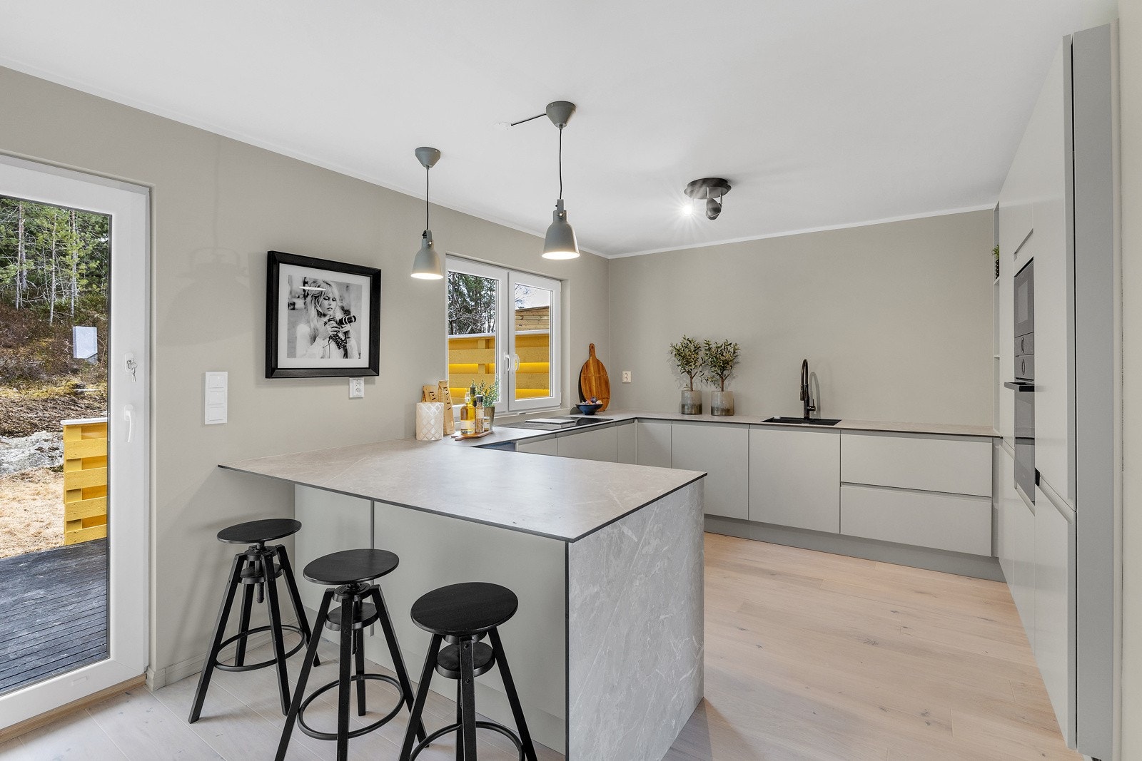 Delikat og moderne kjøkkeninnredning fra HTH med håntakløse grep og praktisk barløsning. Galleribilde