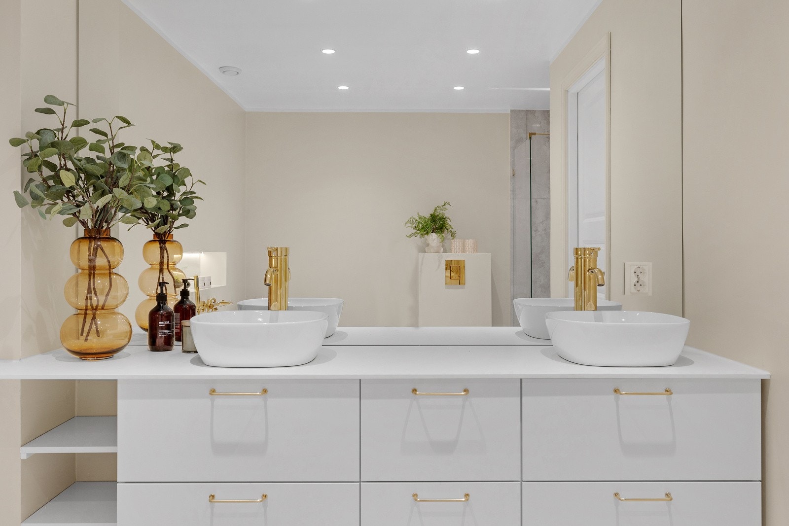 Delikat bad/WC med heldekkende speil over stilren plassbygd servantinnredning. Galleribilde