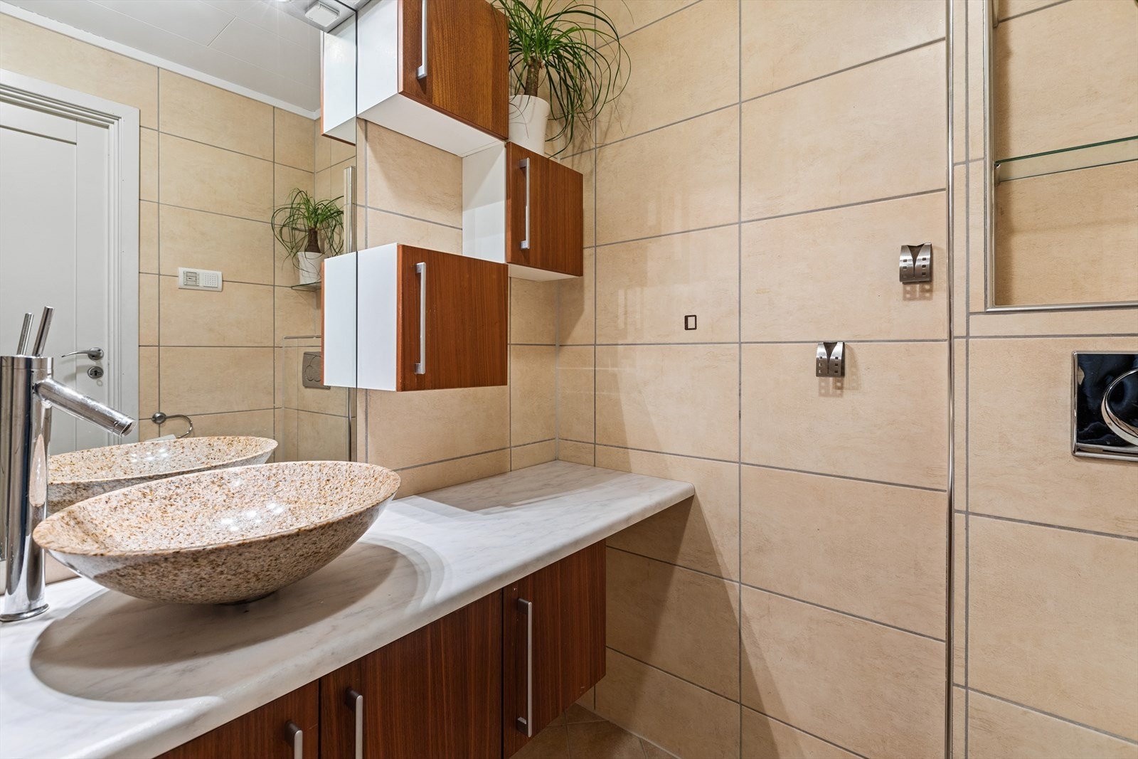 Badet er videre utstyrt med innmurt badekar, servant, servantskap, speil og vegghengt toalett Galleribilde