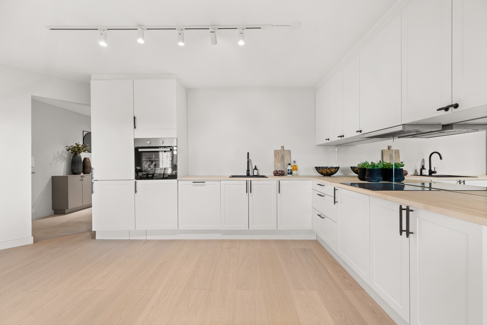 Videre er kjøkkenet utstyrt med integrerte hvitevarer som platetopp, komfyr, oppvaskmaskin og kjøleskap med frysedel Galleribilde