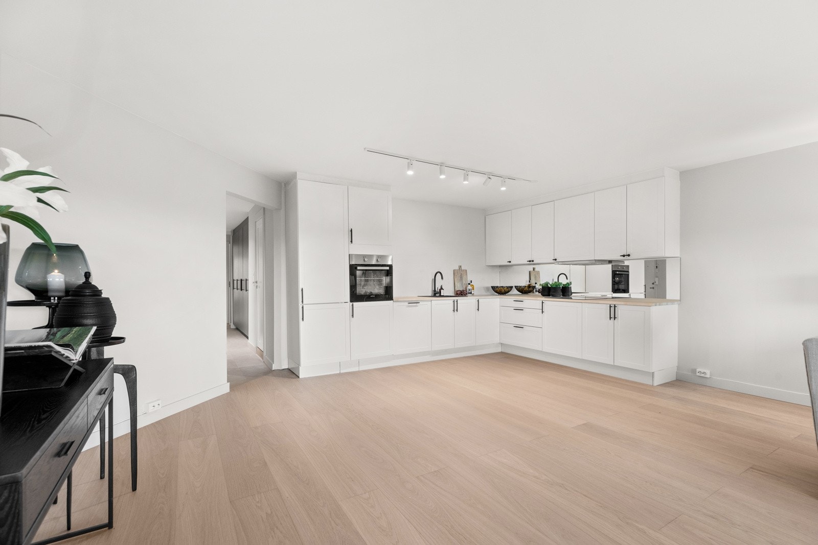 I forbindelse med oppussingen ble det også satt inn et nytt, stilrent kjøkken. Innredningen har hvite, profilerte fronter og lys benkeplate i tre med nedfelt kum i kompositt Galleribilde