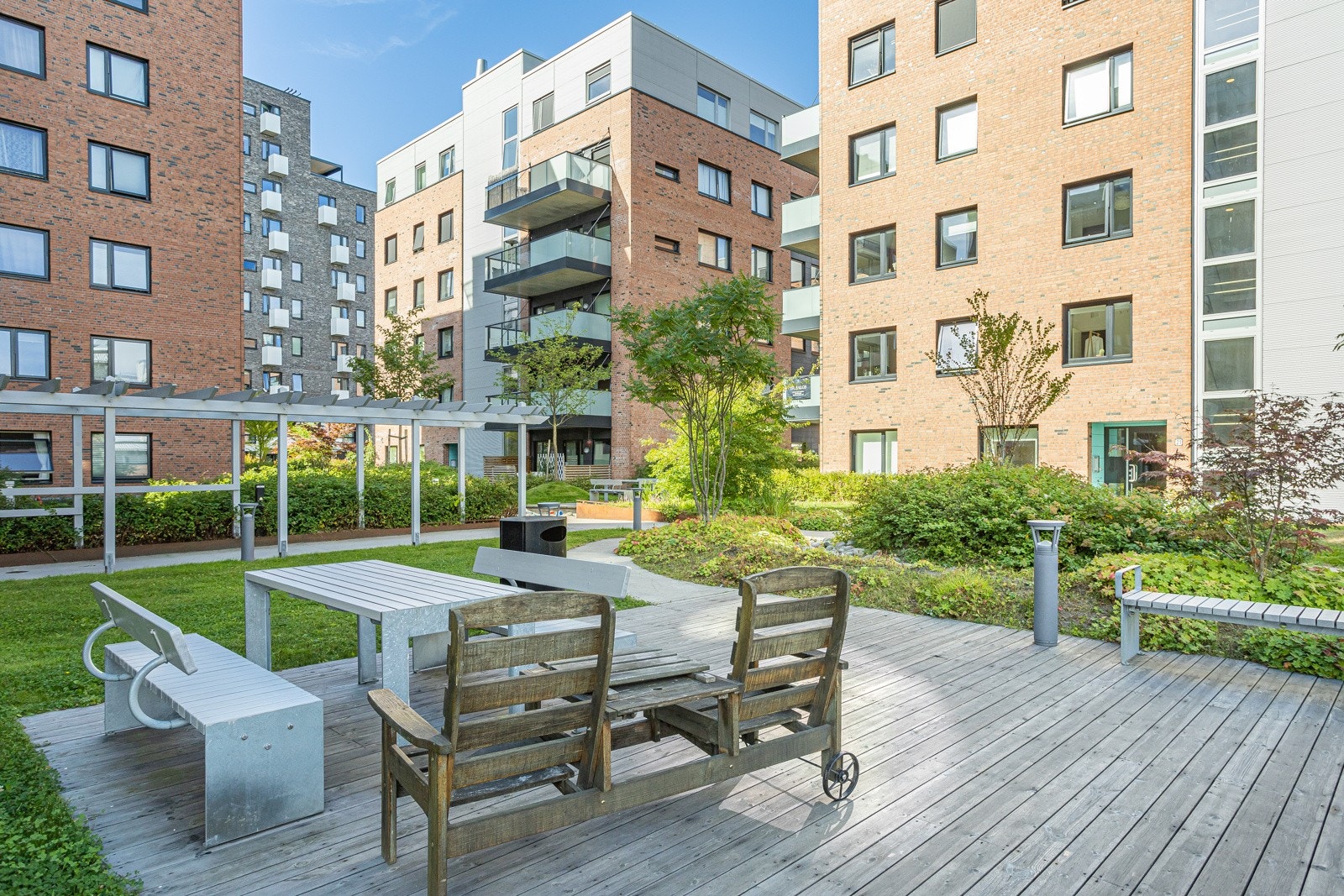 Pent opparbeidede utearealer med sittegrupper og beplantning Galleribilde