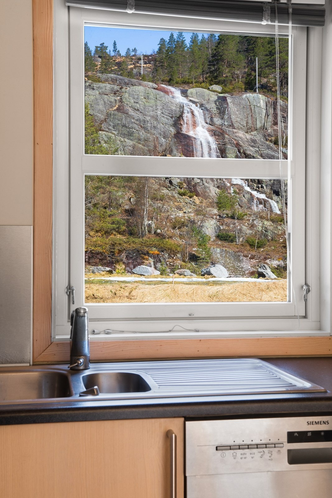 Fra kjøkkenet har du flott utsikt til den vakre fossen bak hytten Galleribilde