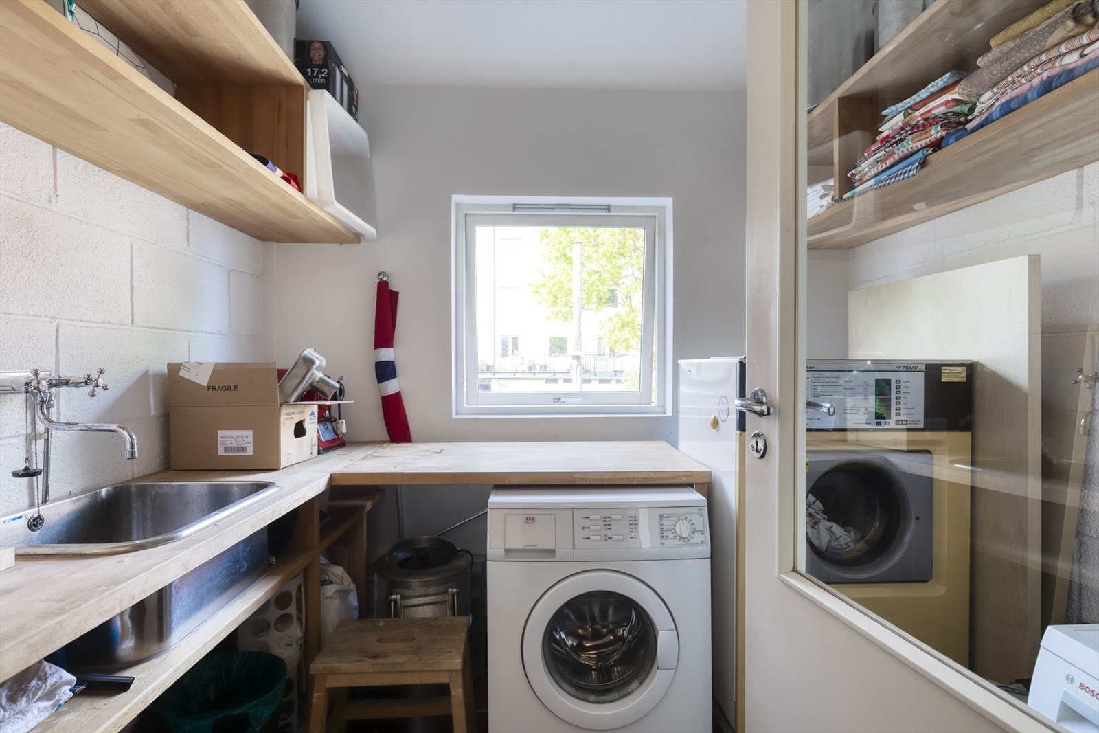 Felles vaskeri vegg i vegg med leiligheten med benk og uslagsvask Galleribilde