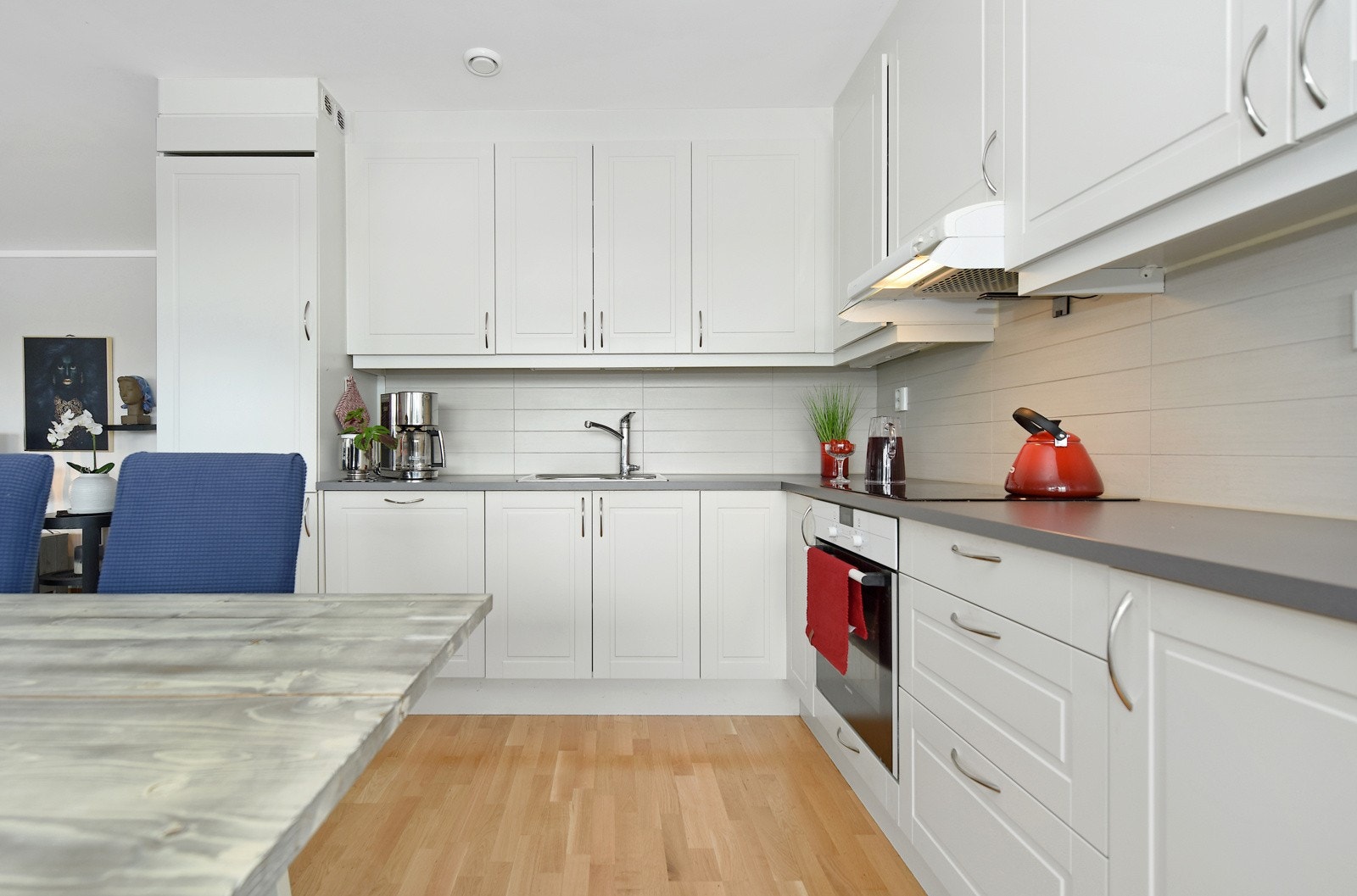 Pent og praktisk kjøkken med takhøye overskap. Galleribilde