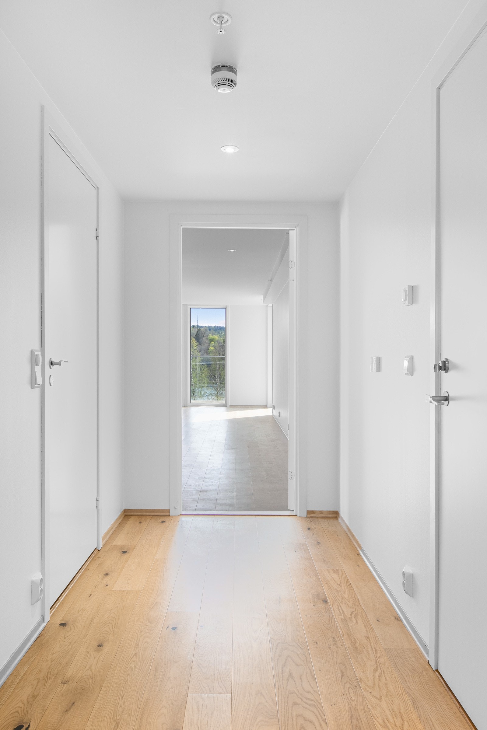 Innbydende entre/gang med malte slette veggflater og nydelig lyspigmentert enstavs parkett på gulv, som gir et godt førsteinntrykk av leiligheten. Himlingen er pent lyssatt med LED downlights. God plass til å sette inn garderobeløsning i praktisk nisje. Galleribilde