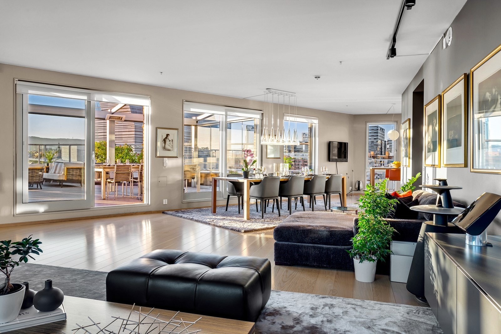 Stor stue med vinduer på tre sider. Dobbel skyvedør ut til terrassen Galleribilde