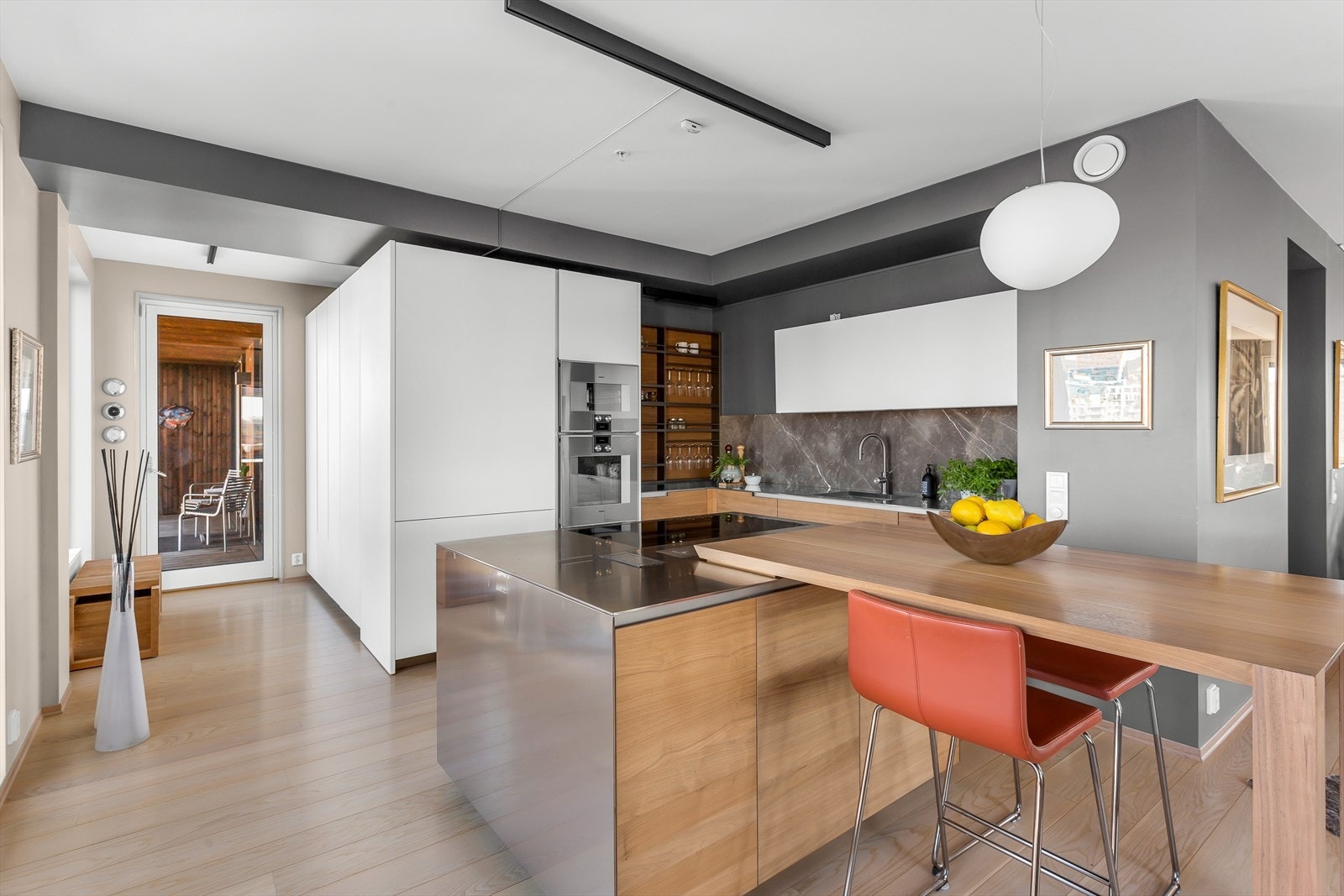 Delikat designkjøkken med marmor backsplash. Integrert bredt kjøl- og fryseskap fra Gaggenau med bl.a. isbitmaskin og elektrisk glasshylle Galleribilde