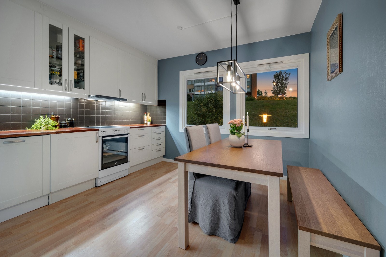 Kveldsstemning rundt middagsbordet. Det er integrert oppvaskmaskin, frittstående komfyr og ventilator (Røroshetta) over stekesone som medfølger boligen. Galleribilde