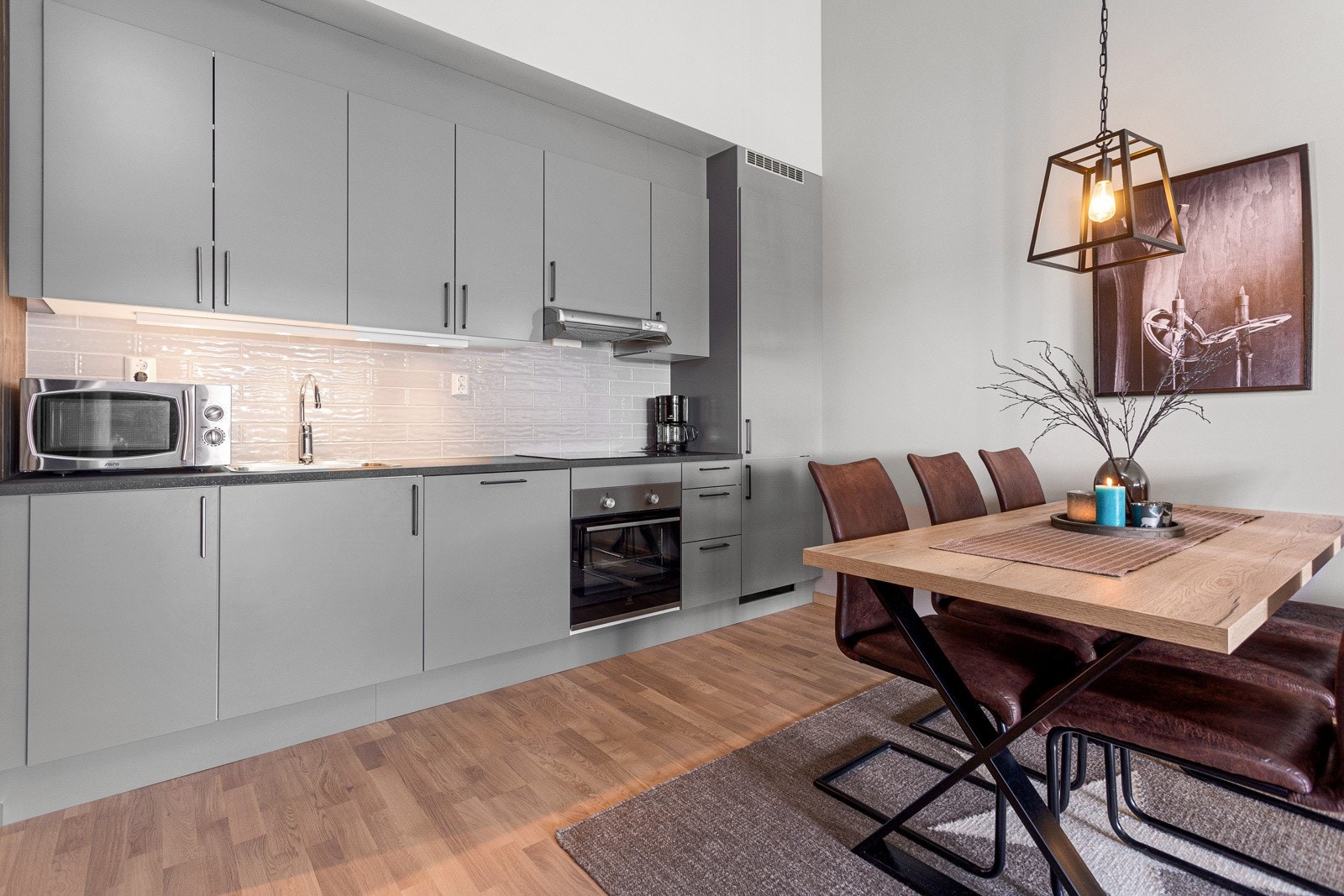 Kjøkken med gråmalte fronter og integrerte hvitevarer. Galleribilde