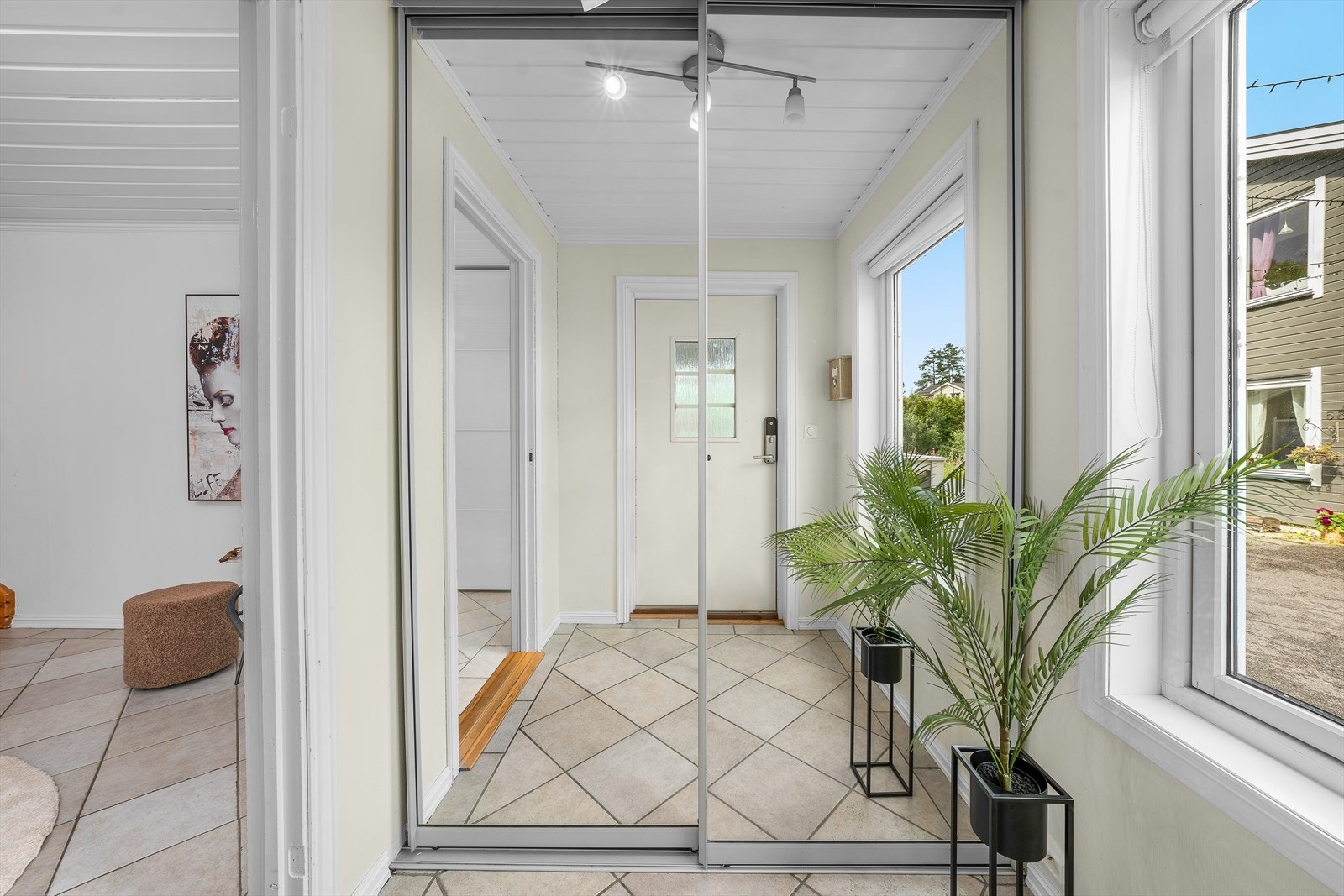 Flislagt entré med skyvedørsgarderobe. Galleribilde