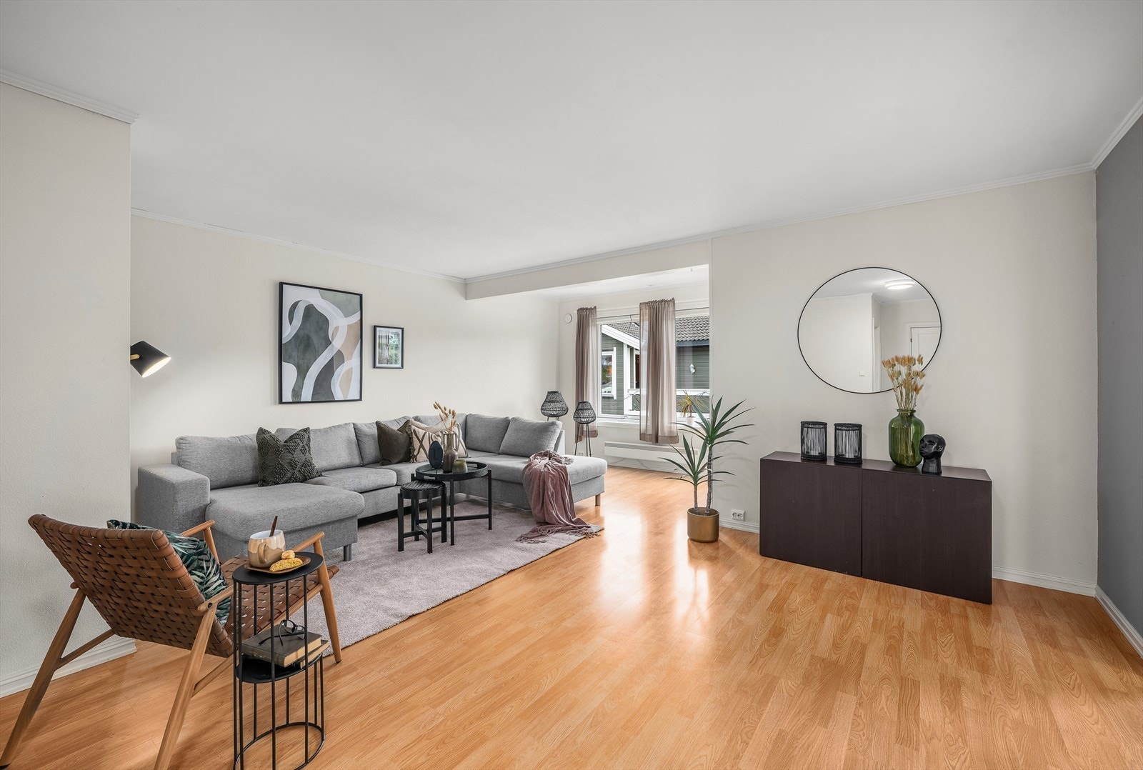 Lys og luftig stue med lysmalte veggflater, og laminatgulv. Galleribilde