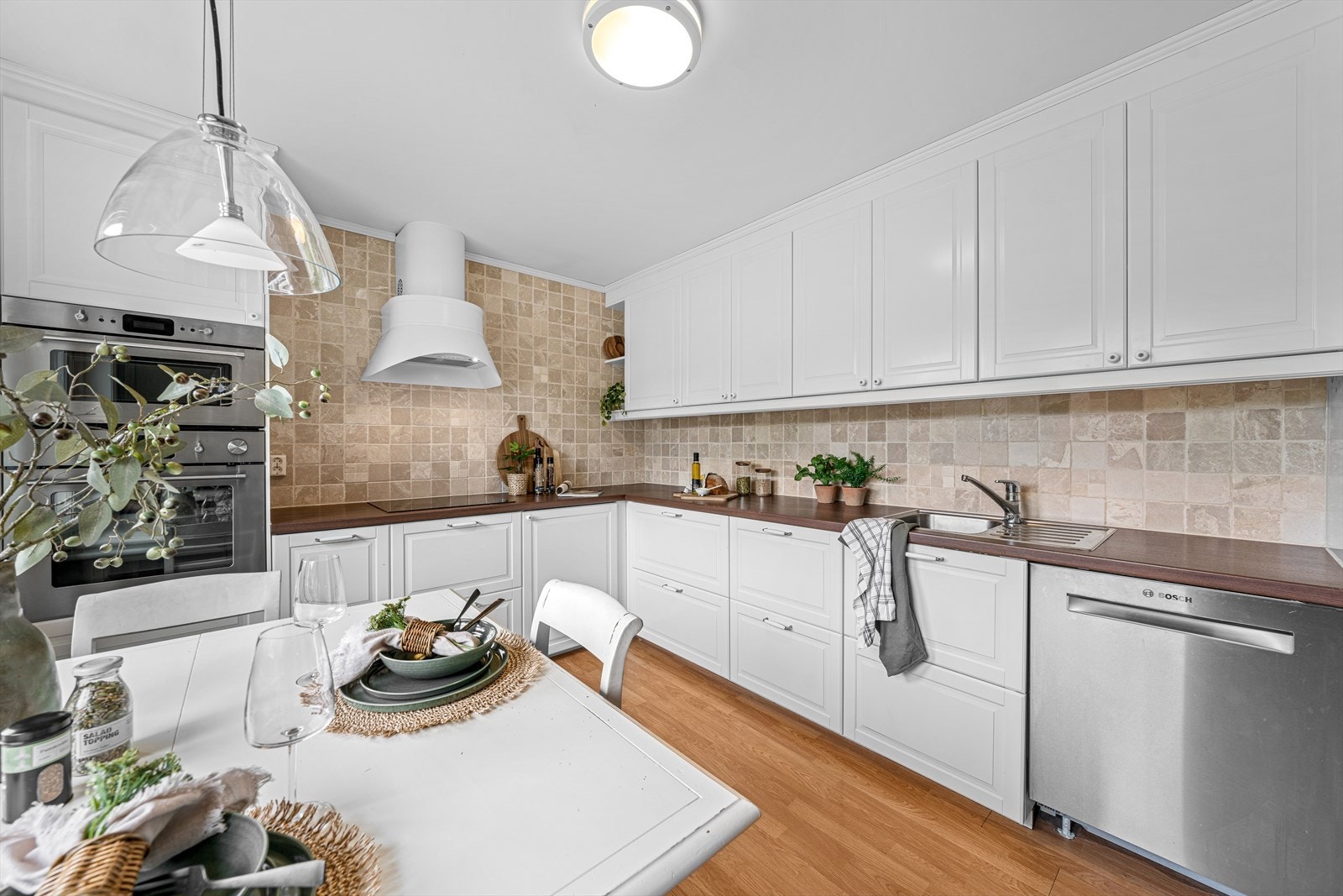 Kjøkkenet fra IKEA har profilerte fronter, og det er fliser mellom benkeplate og overskap. Galleribilde