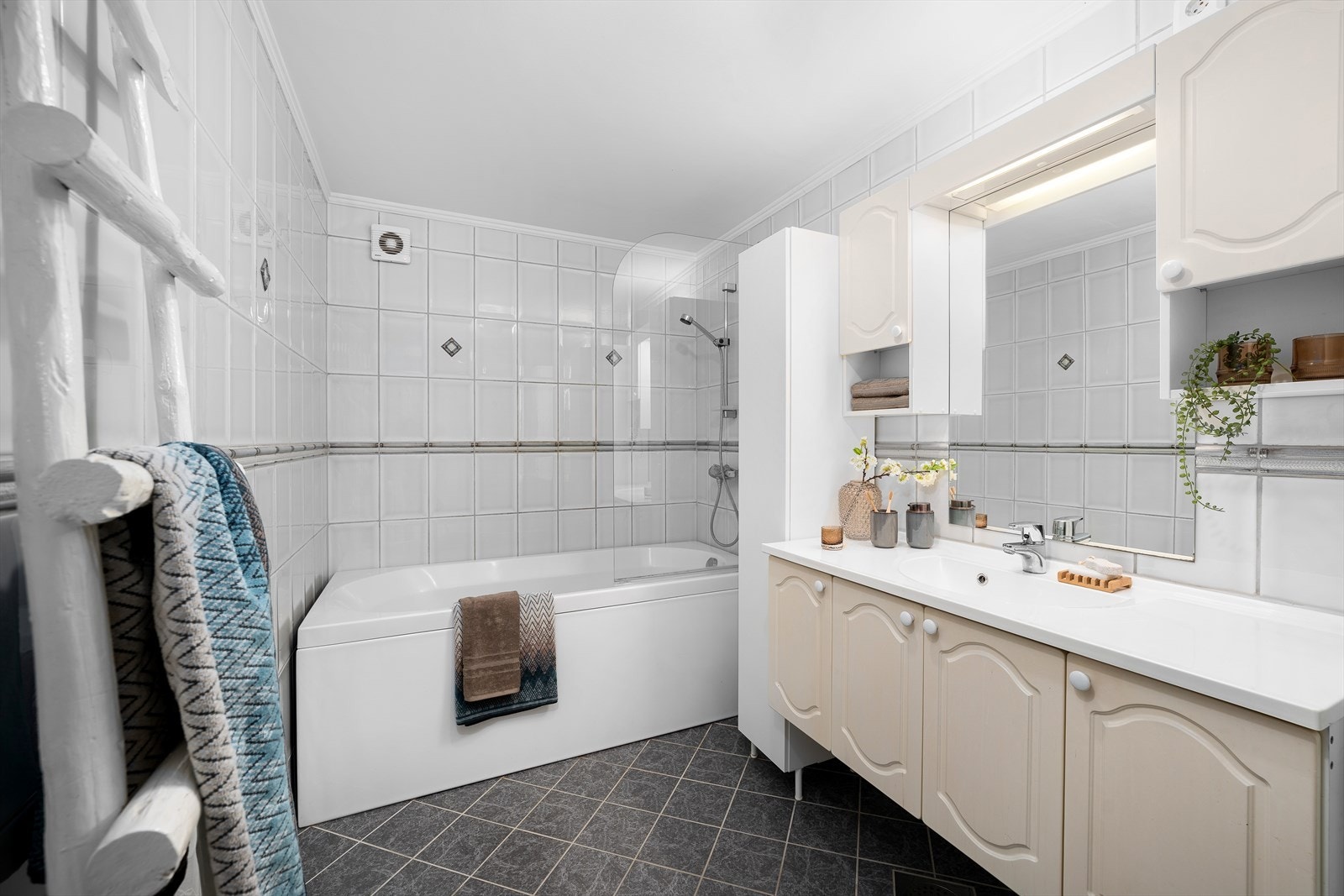 Badet i 2. etasje er flislagt, og byr på skapinnredning med servant, badekar med dusjmuligheter, og et toalett. Galleribilde