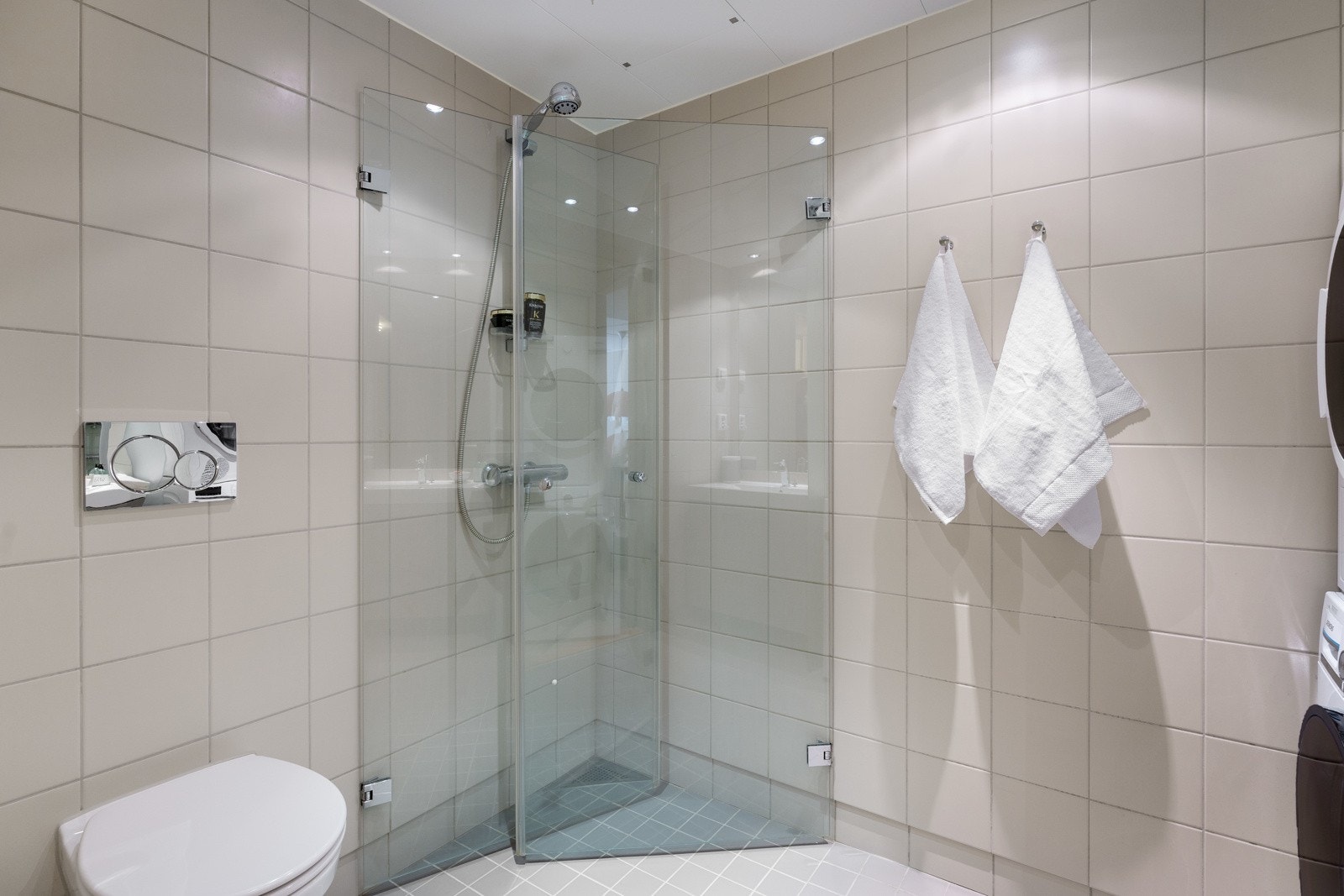Badet har fliser i farger som er godt avstemt med de delikate fargene i leiligheten Galleribilde
