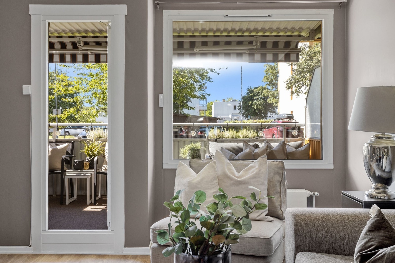 Rolige omgivelser utenfor stuevindu med grøntarealer og elektrisk markise for dagene der man ønsker å skjerme solen Galleribilde